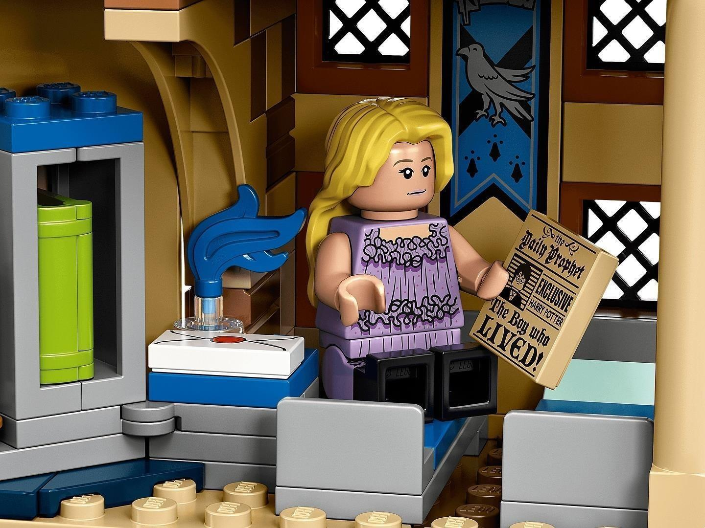 Eine blonde Lego-Minifigur im lila Kleid hält eine Tagesprophet-Zeitung in einem Zimmer mit blauem Banner.