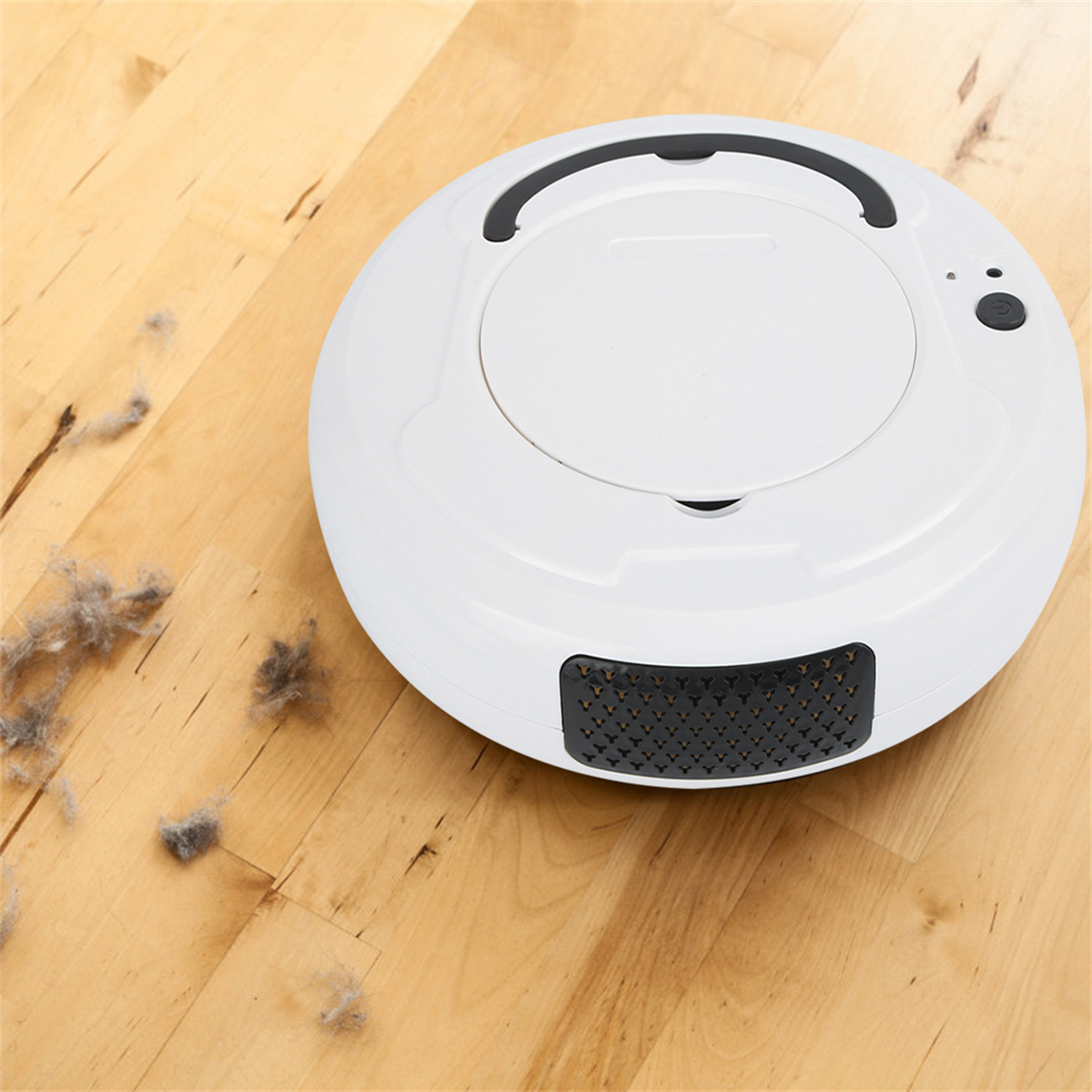 Ein weißer Saugroboter steht auf einem Holzboden neben kleinen Staubflusen.