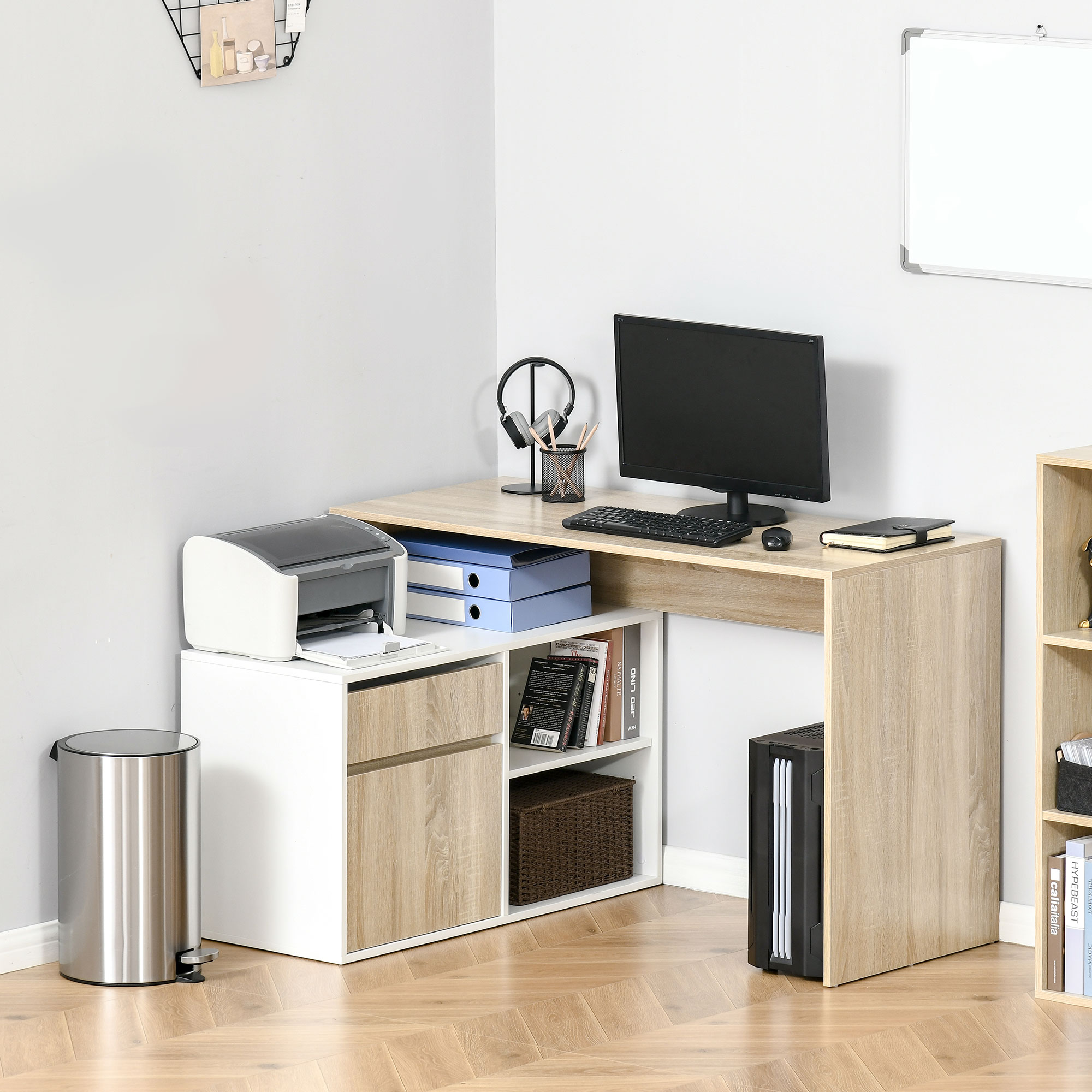 Scrivania in legno con computer, monitor, stampante e raccoglitori in una stanza con pavimento in legno chiaro.