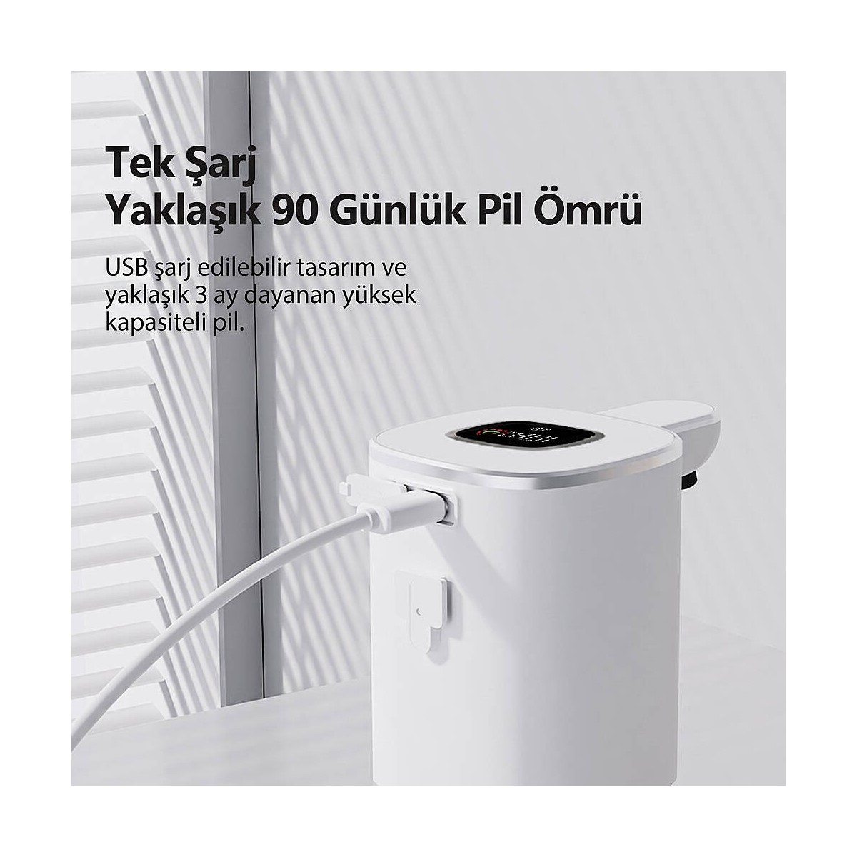 Beyaz silindirik su sebili, panjur arka planında bir USB kablosuyla şarj ediliyor.