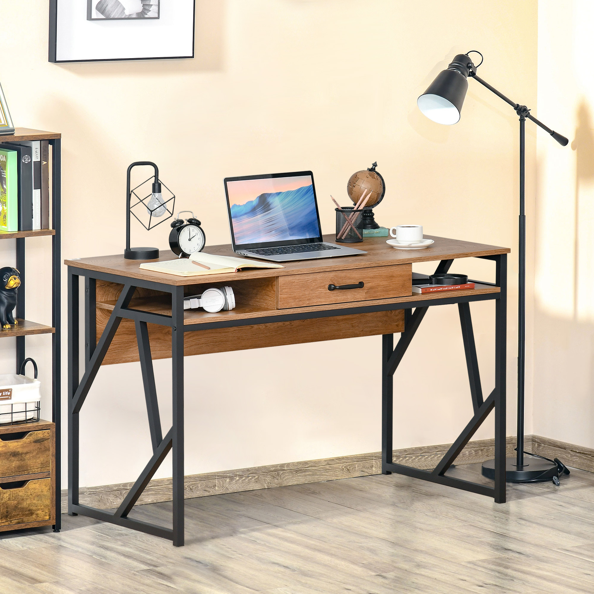 Scrivania in legno con struttura in metallo nero con laptop, lampada, orologio e mappamondo.