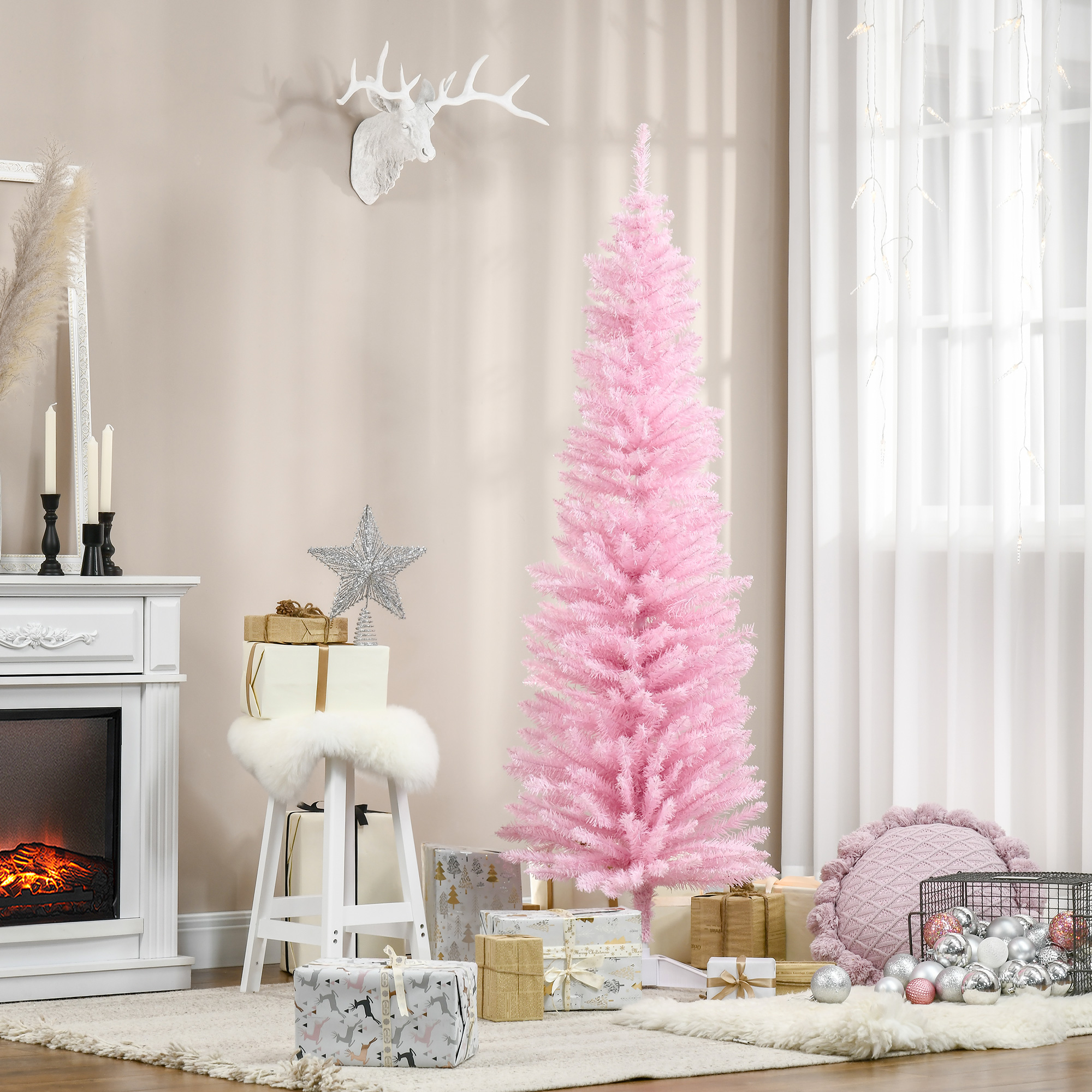 Un árbol de Navidad rosa se encuentra en una habitación decorada con regalos, una chimenea blanca y una cabeza de ciervo.