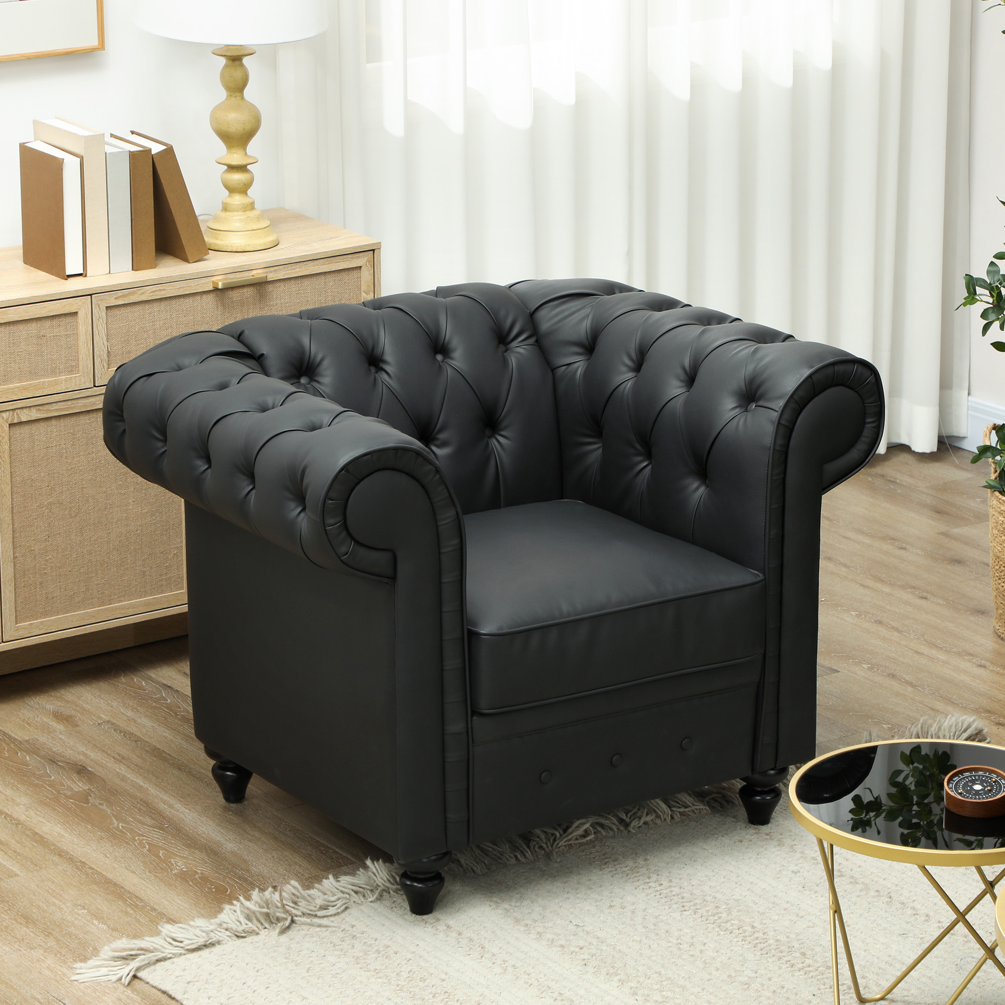 Una poltrona Chesterfield in pelle nera trapuntata si trova in una stanza.