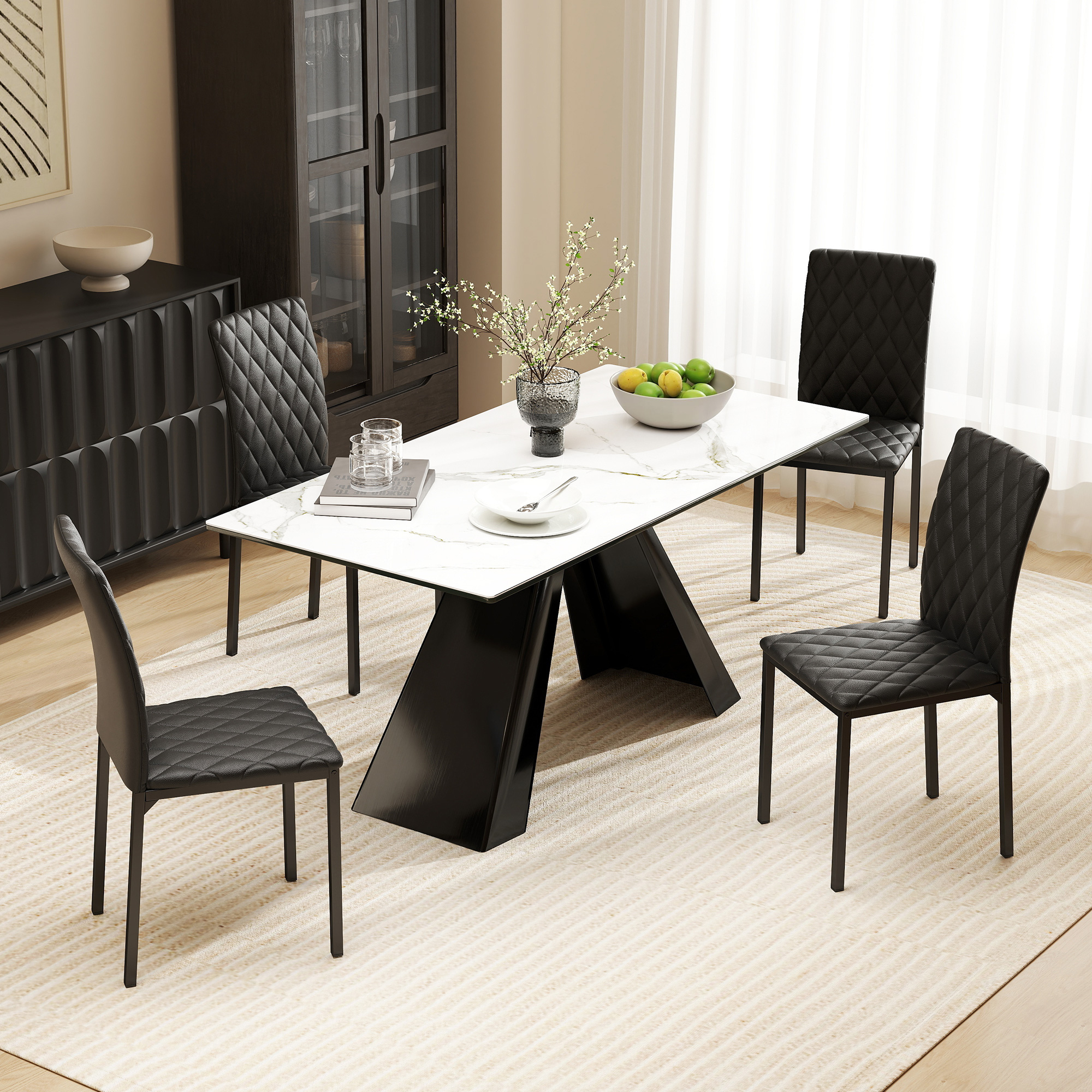 Moderno tavolo da pranzo con piano in marmo bianco e quattro sedie nere trapuntate in una stanza luminosa.