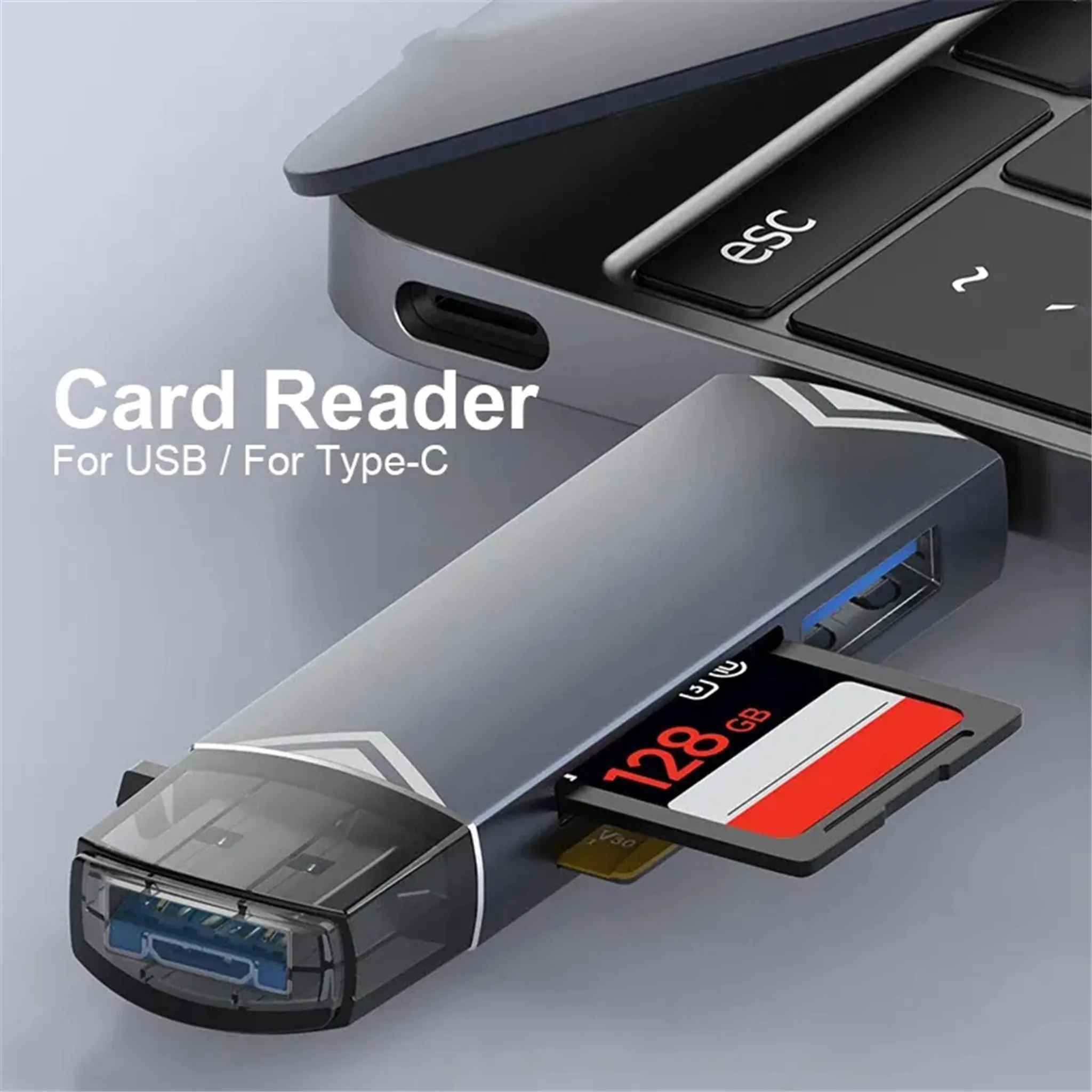 Ein grauer USB-Kartenleser mit eingesteckter 128GB Speicherkarte liegt neben einem Laptop.