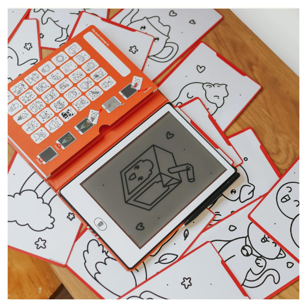 Ein orangefarbenes elektronisches Zeichenbrett mit Stift und vielen Malvorlagen liegt auf einem Holztisch.