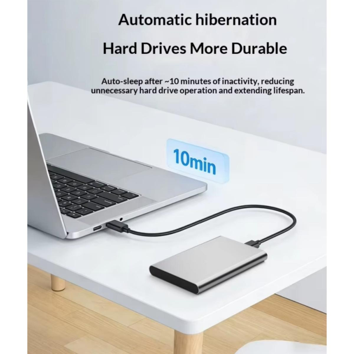 Ein silbernes Laptop und eine externe Festplatte auf weißem Tisch mit Text über automatisches Ruhezustand.