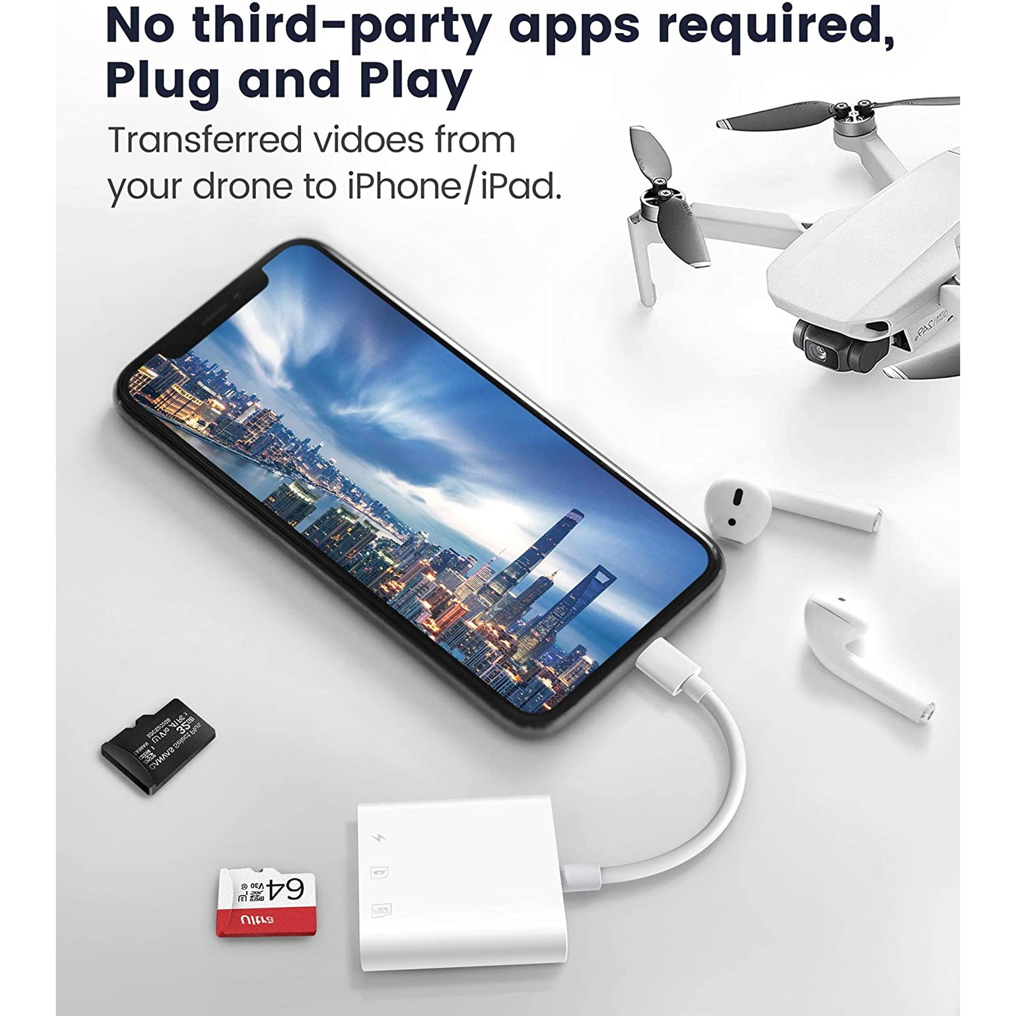 Ein Smartphone an Kartenleser angeschlossen, mit Drohne, Speicherkarten und Kopfhörern auf weißer Oberfläche.