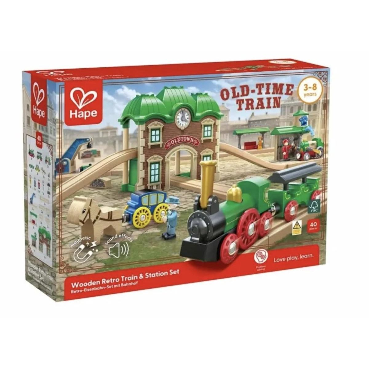 Verpackung eines Hape Retro-Holzeisenbahn-Sets mit Bahnhof, grünem Zug und Figuren.