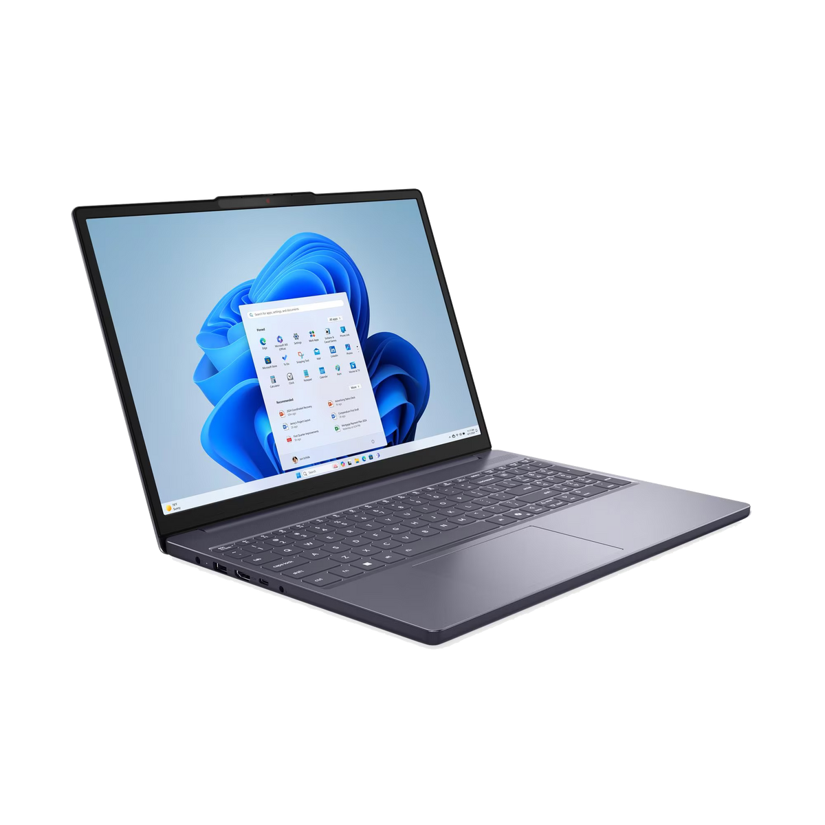Un portátil gris moderno abierto, con un escritorio Windows azul y menú de inicio sobre fondo negro.