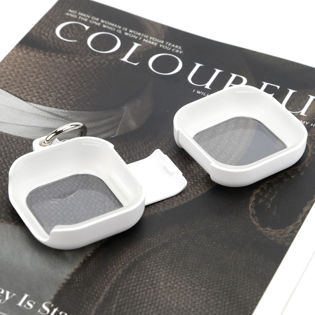 Zwei weiße schutzhüllen für apple airtags auf einer magazinseite.