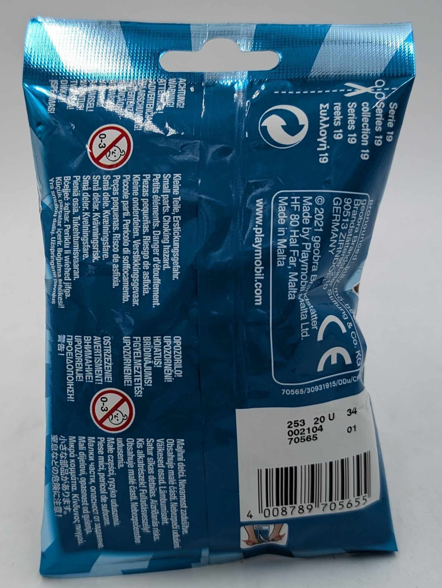 Parte trasera de un sobre azul sorpresa de Playmobil Serie 19 con advertencias y código de barras.