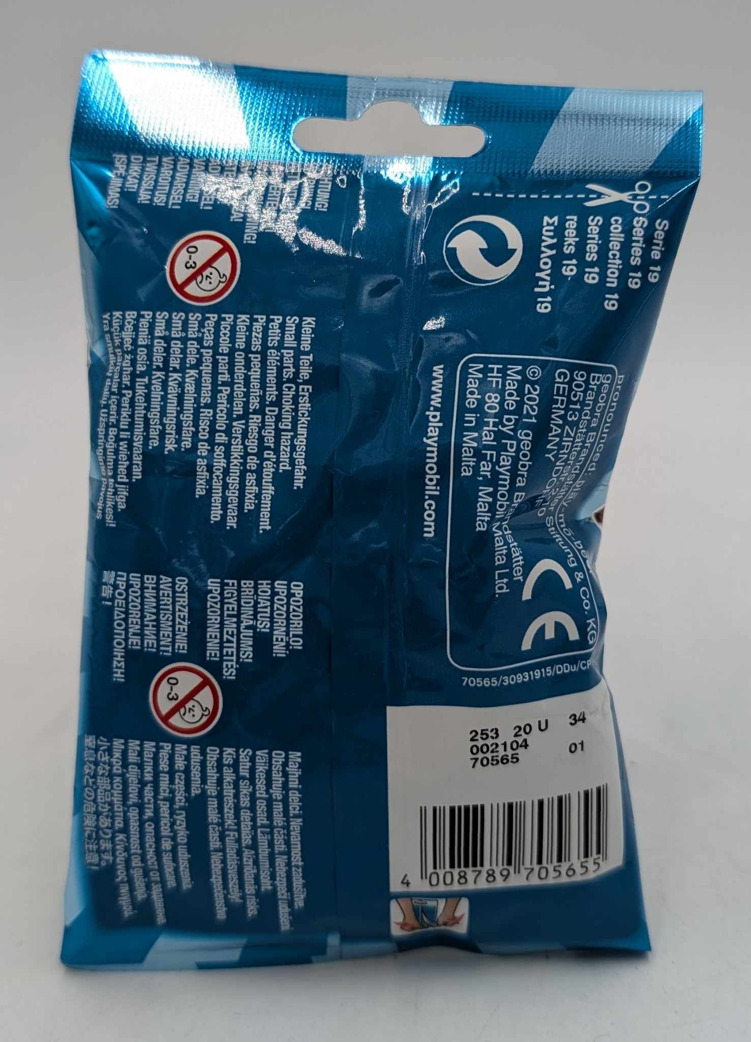 La parte trasera de una bolsa sorpresa azul de Playmobil con advertencias y código de barras.