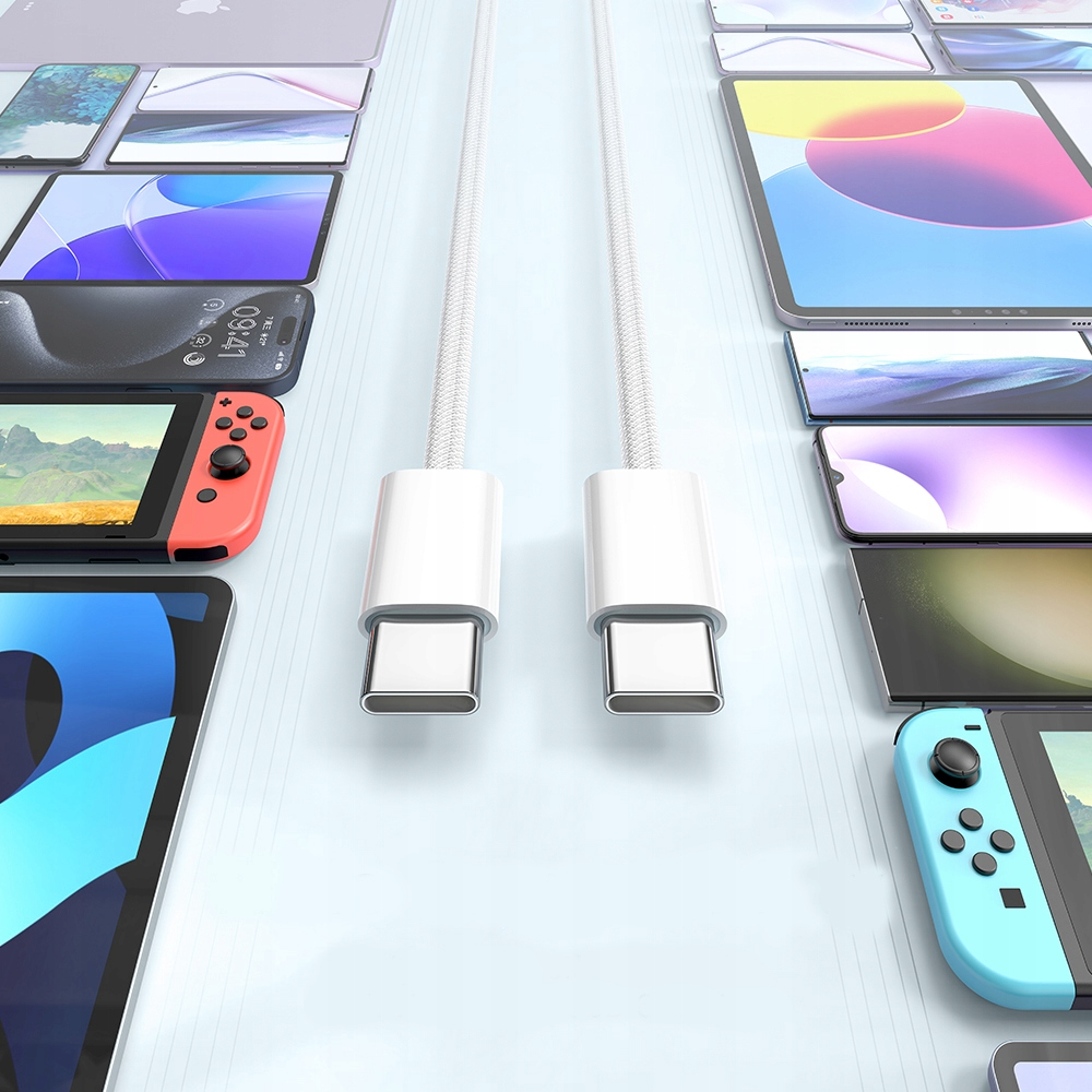 Due cavi USB-C bianchi sono posizionati tra vari smartphone, tablet e console su sfondo chiaro.