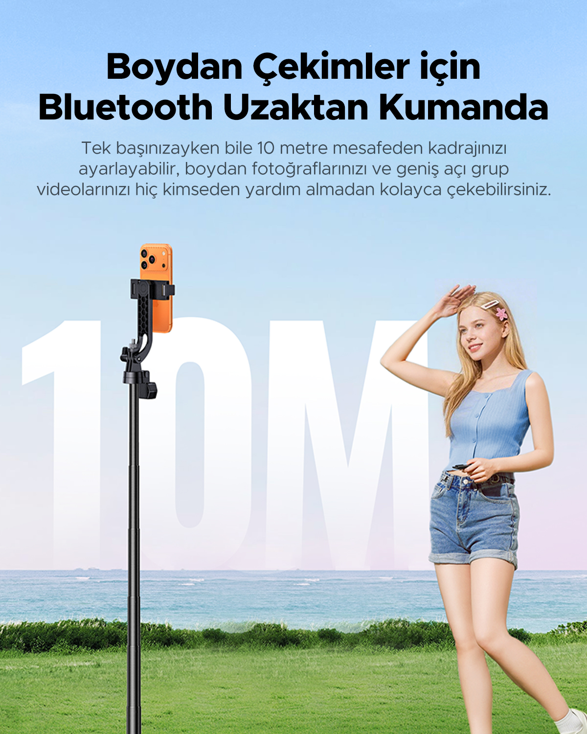 Telefon tutan selfie çubuğu ve deniz arka planında poz veren sarışın kadın.