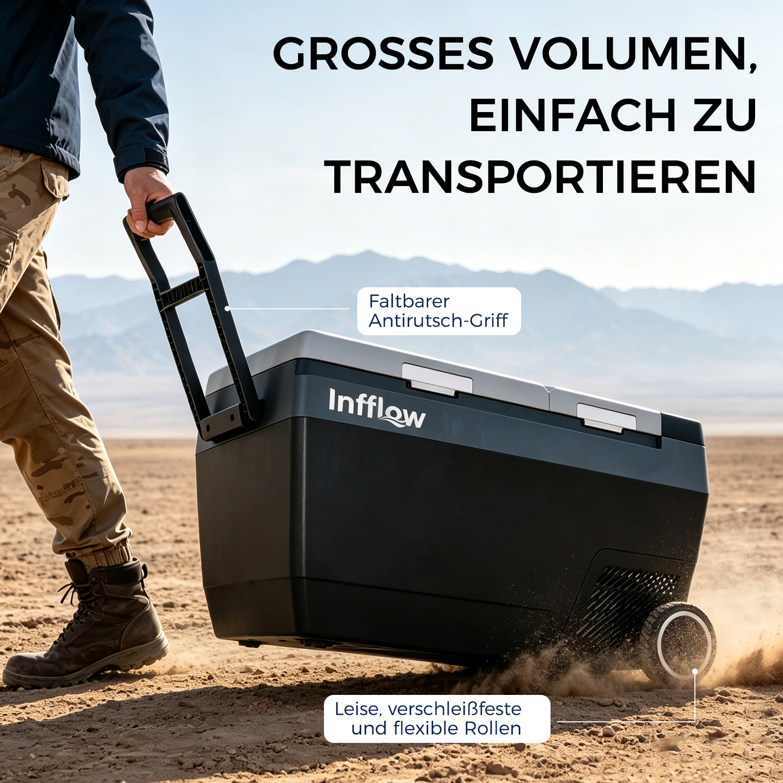 Ein Mann zieht eine große, schwarze Infflow Kühlbox mit Rollen durch eine Wüstenlandschaft.