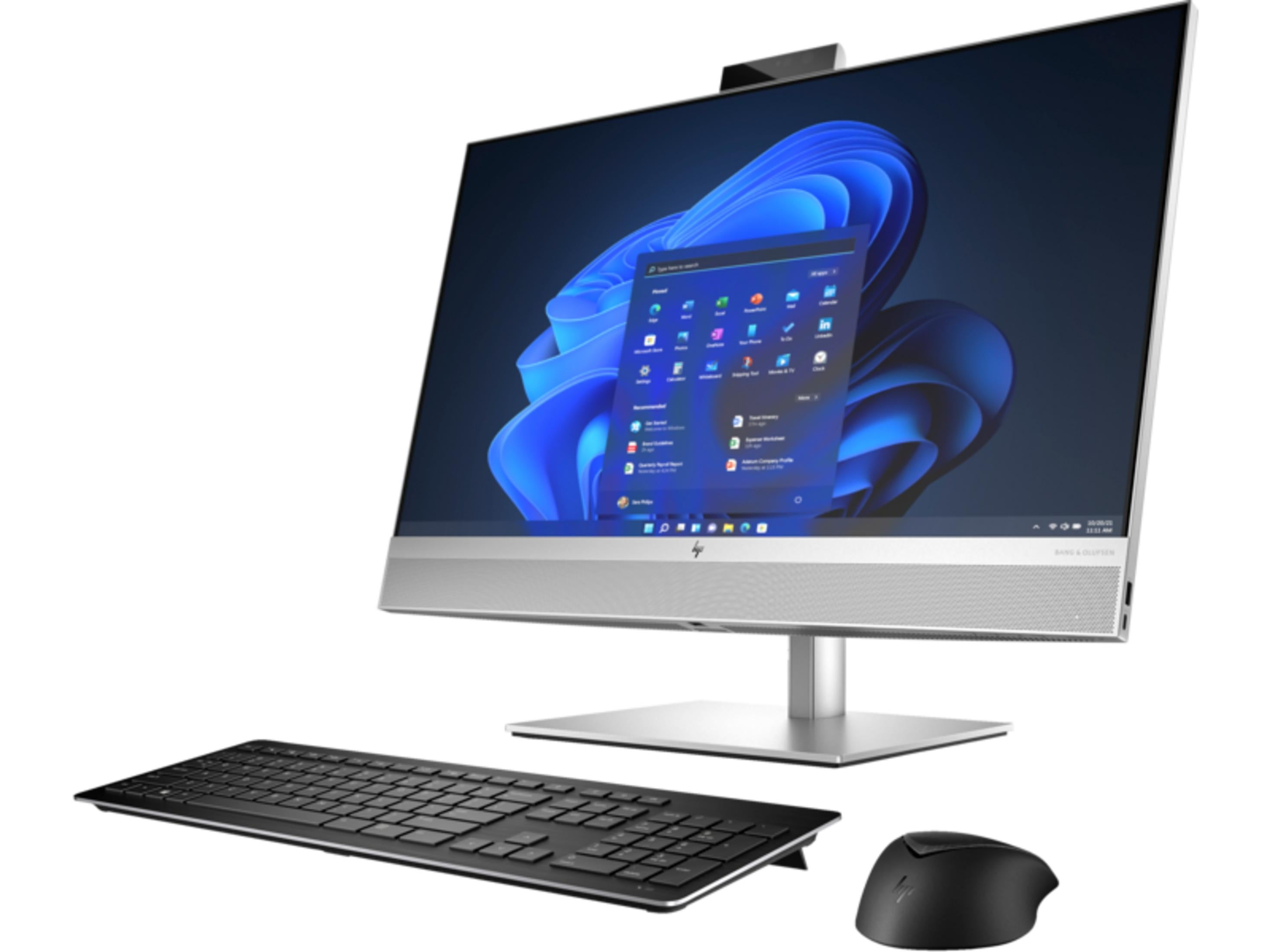 Srebrny komputer stacjonarny typu all-in-one z niebieską tapetą Windows, czarną klawiaturą i myszką na białym tle.
