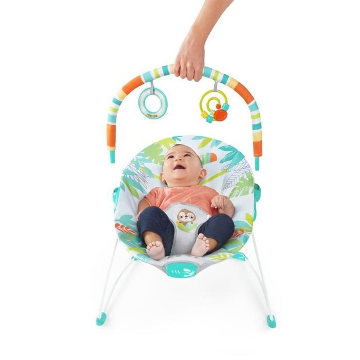 Ein glückliches Baby sitzt in einer bunten Wippe mit einem Spielbogen, gehalten von einer Hand.