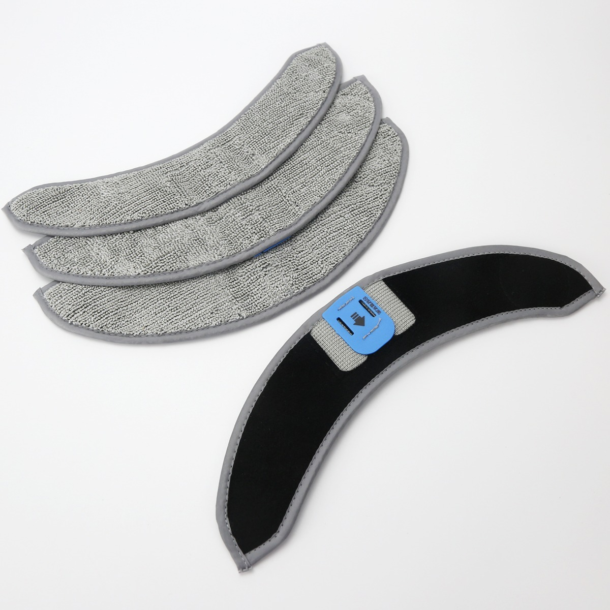 Vier graue Mop-Pads mit Mikrofaser und ein umgedrehtes Pad mit blauem Clip auf weißem Grund.