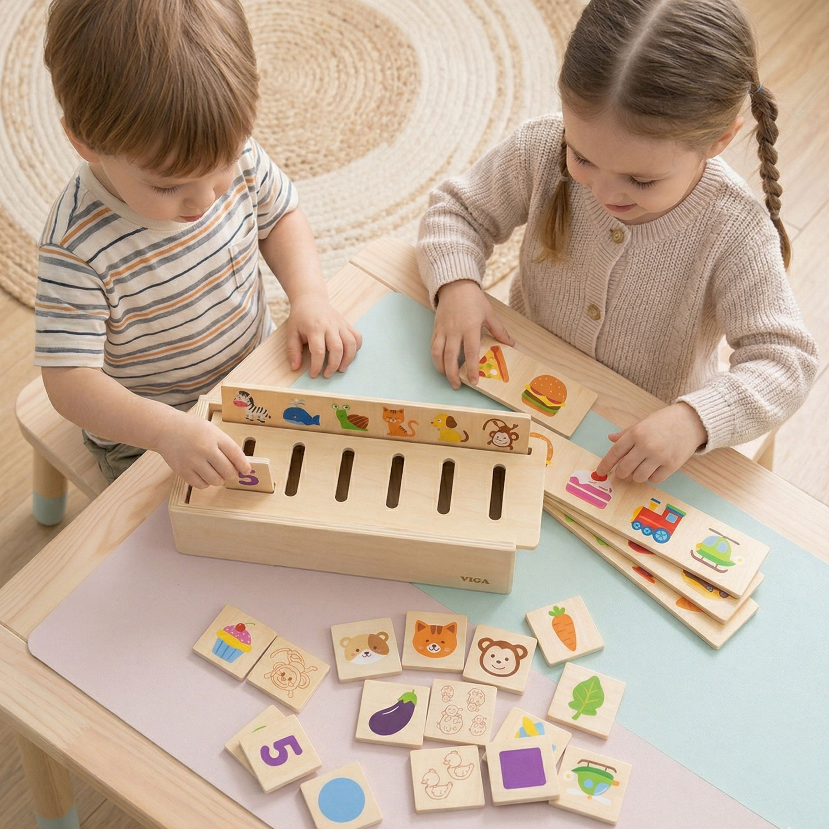 Dos niños pequeños están sentados a la mesa jugando concentrados con un juguete de madera y fichas coloridas.