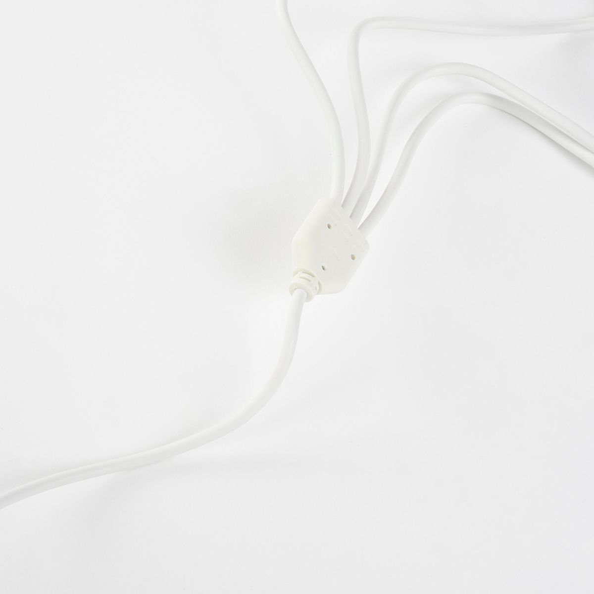 Ein weißes Kabel teilt sich in drei Richtungen auf einem weißen Hintergrund.