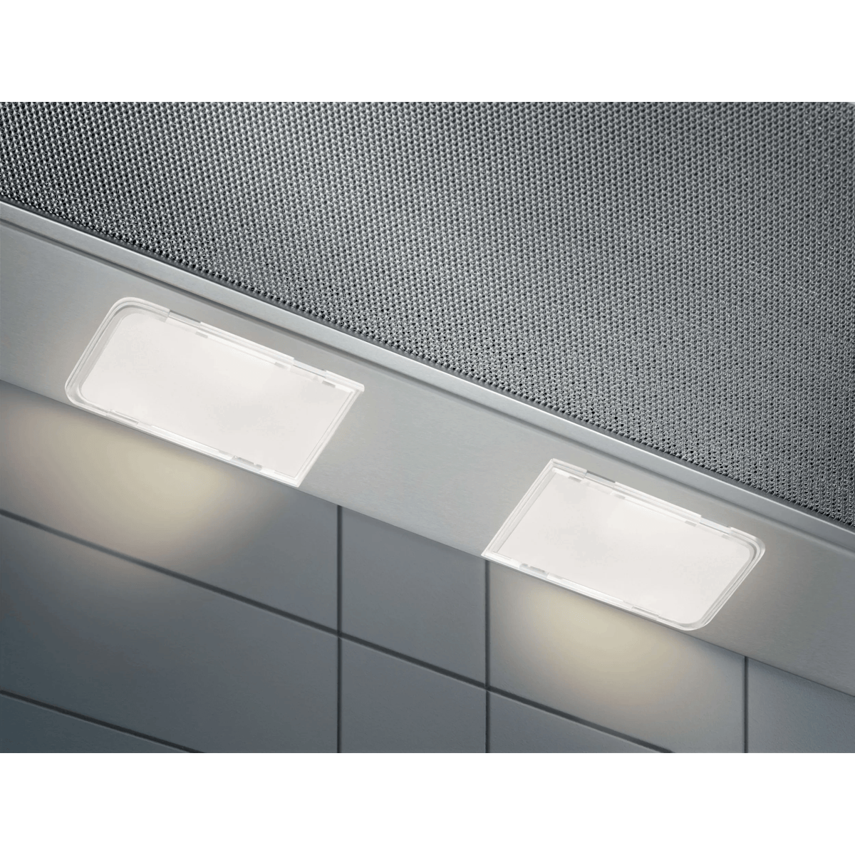 Dos luces LED rectangulares brillantes instaladas bajo una campana extractora de acero inoxidable sobre una pared de azulejos.