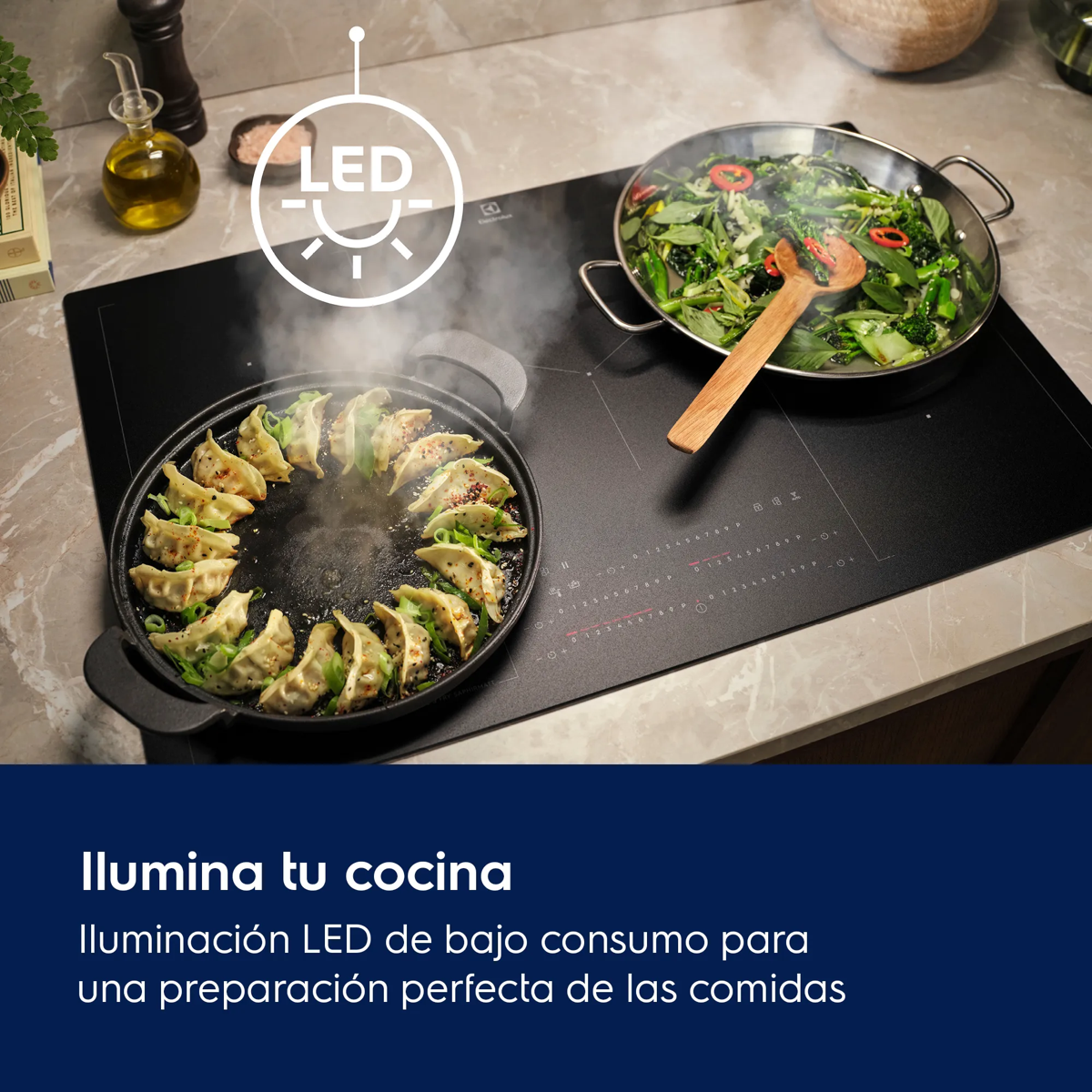 Placa iluminada por LED con sartenes que contienen albóndigas y verduras al vapor.