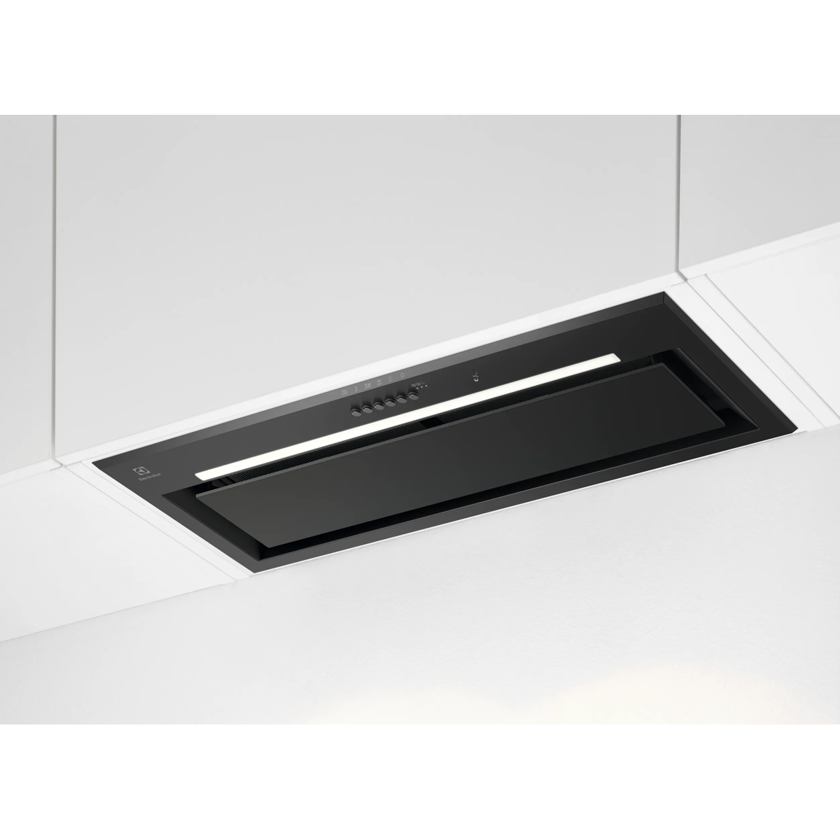 Una campana extractora negra está integrada en un armario de cocina blanco e iluminada.