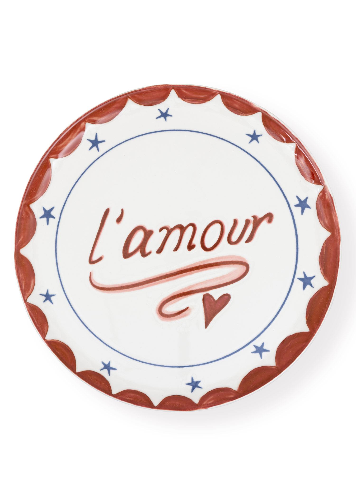 Kırmızı dalgalı kenarlı, mavi yıldızlı ve l'amour yazılı beyaz dekoratif tabak.