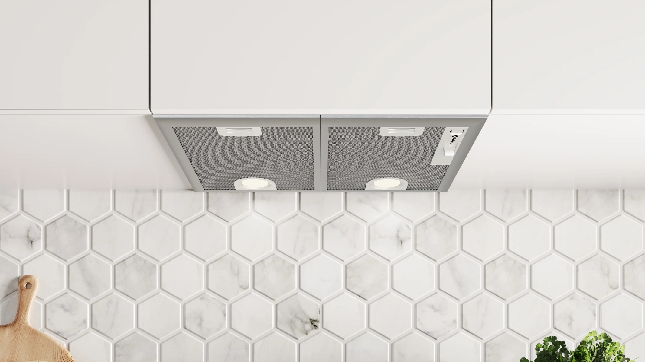 Campana extractora empotrada con filtros de malla y luces bajo armarios blancos, contra una pared de azulejos hexagonales.