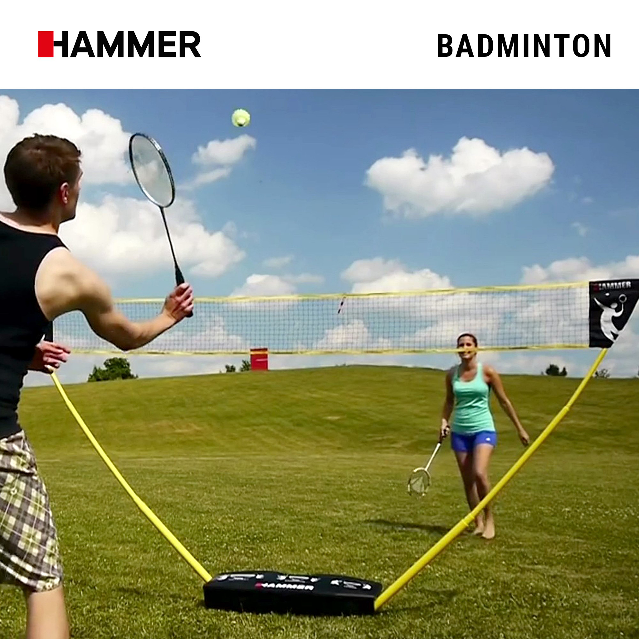 Ein Mann und eine Frau spielen Badminton im Freien auf einer grünen Wiese mit gelbem Netz.