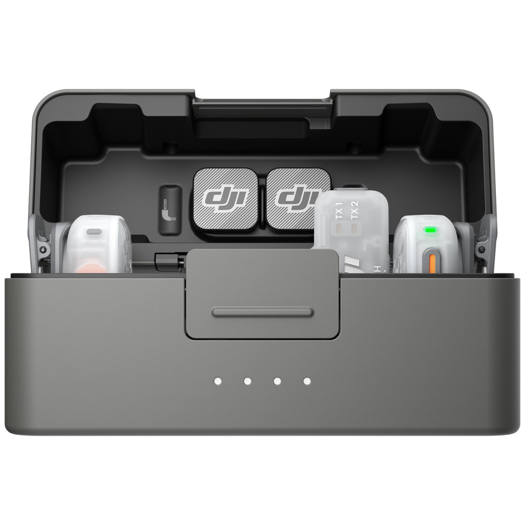 Un estuche de carga DJI gris abierto con dos transmisores de micrófono, antivientos y adaptadores.