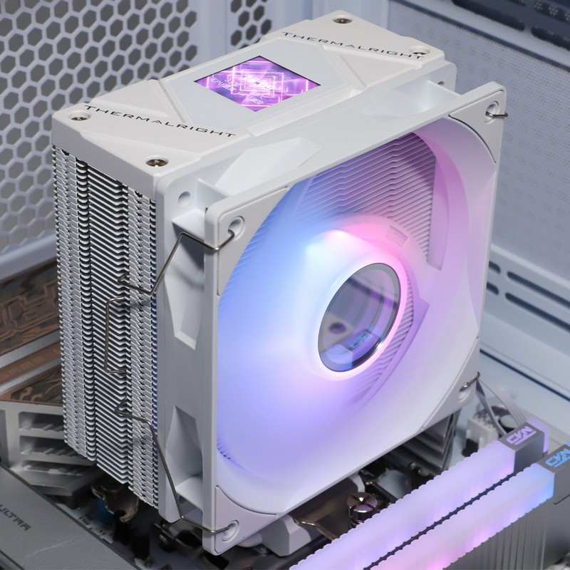 Un dissipatore CPU Thermalright bianco con ventola RGB e un piccolo display in alto in un PC.