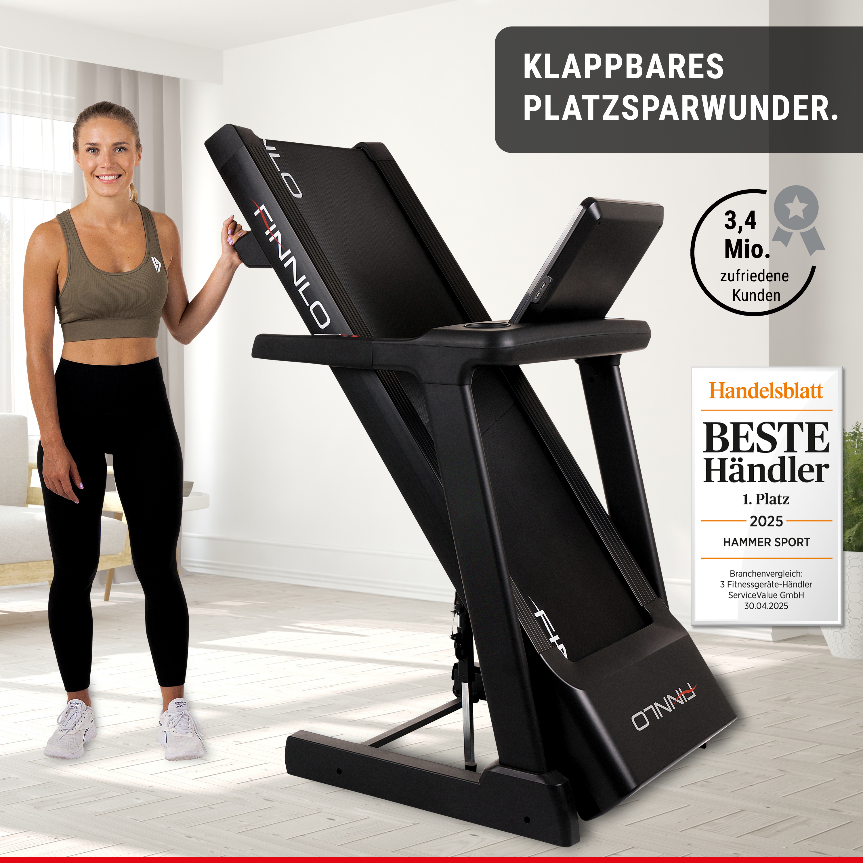 Eine Frau in Sportkleidung posiert neben einem schwarzen, zusammengeklappten Laufband in einem hellen Raum.