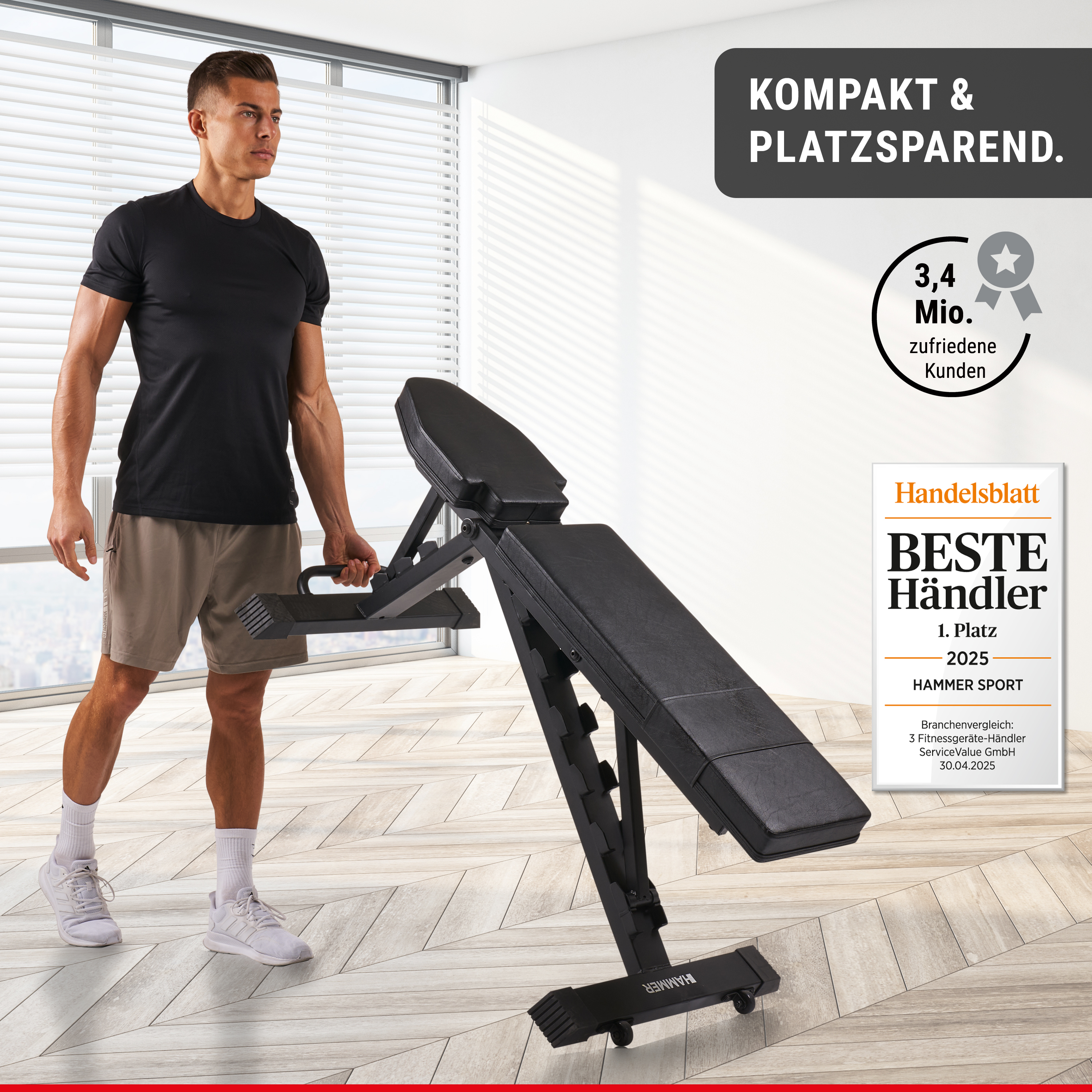 Ein Mann in Sportkleidung hält eine kompakte, schwarze Fitnessbank in einem hellen Raum.