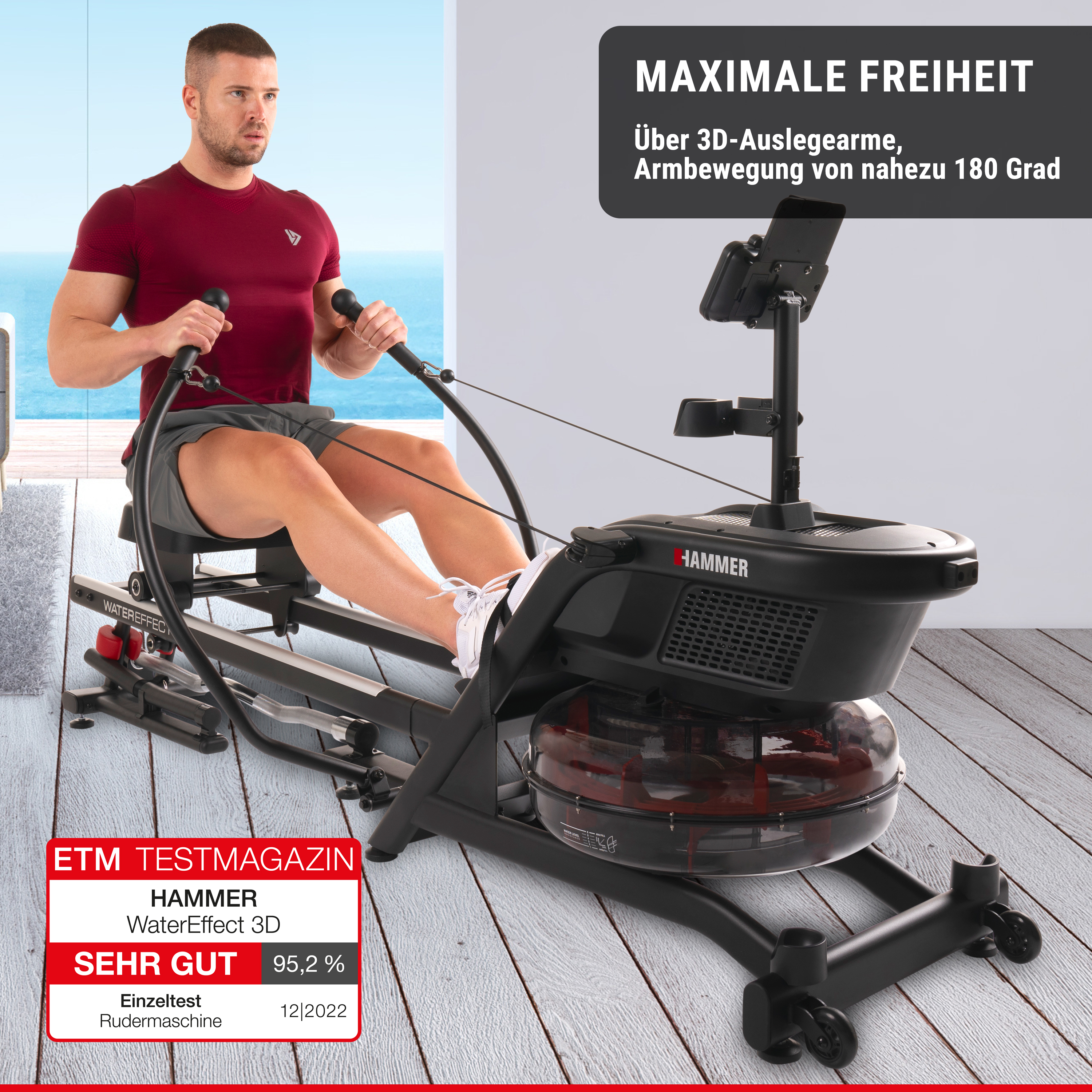 Ein Mann trainiert auf einem schwarzen Hammer WaterEffect 3D Rudergerät auf einer Holzterrasse.