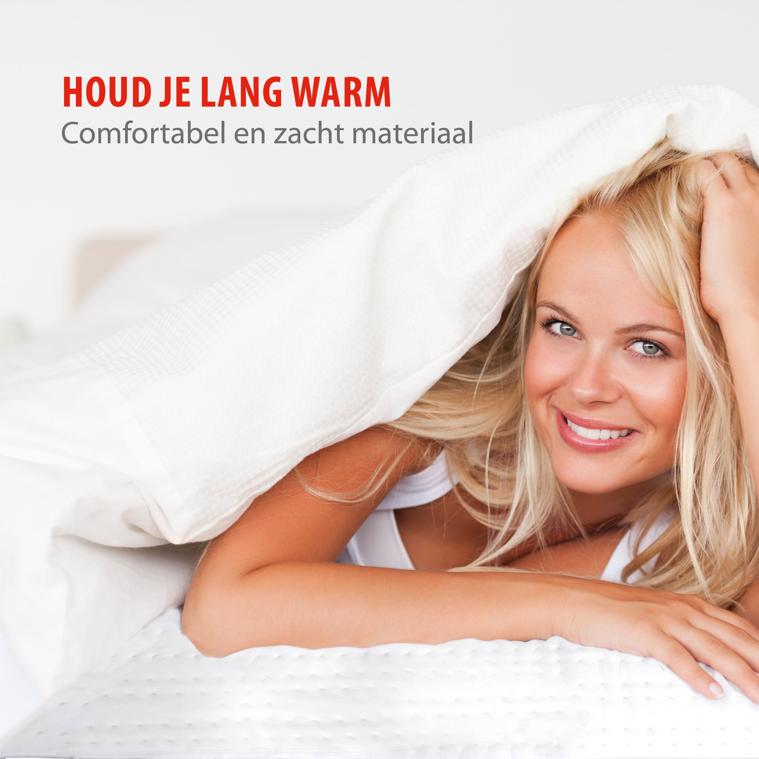Eine lächelnde blonde Frau liegt gemütlich unter einer warmen weißen Decke im Bett.