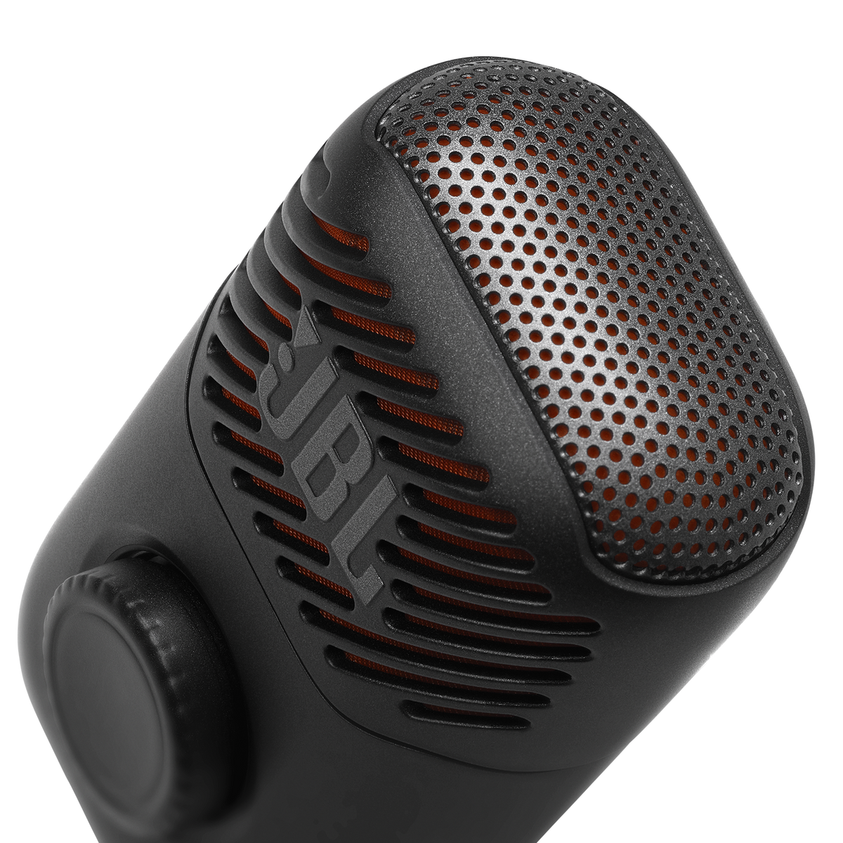 Micrófono JBL negro con rejilla metálica perforada, forro interior naranja y dial de control sobre fondo negro.