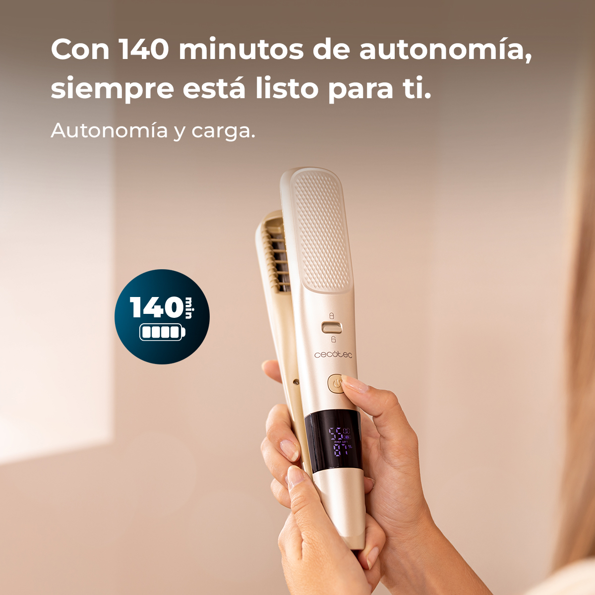 Una mano sostiene una plancha de pelo dorada con pantalla digital. Texto arriba.