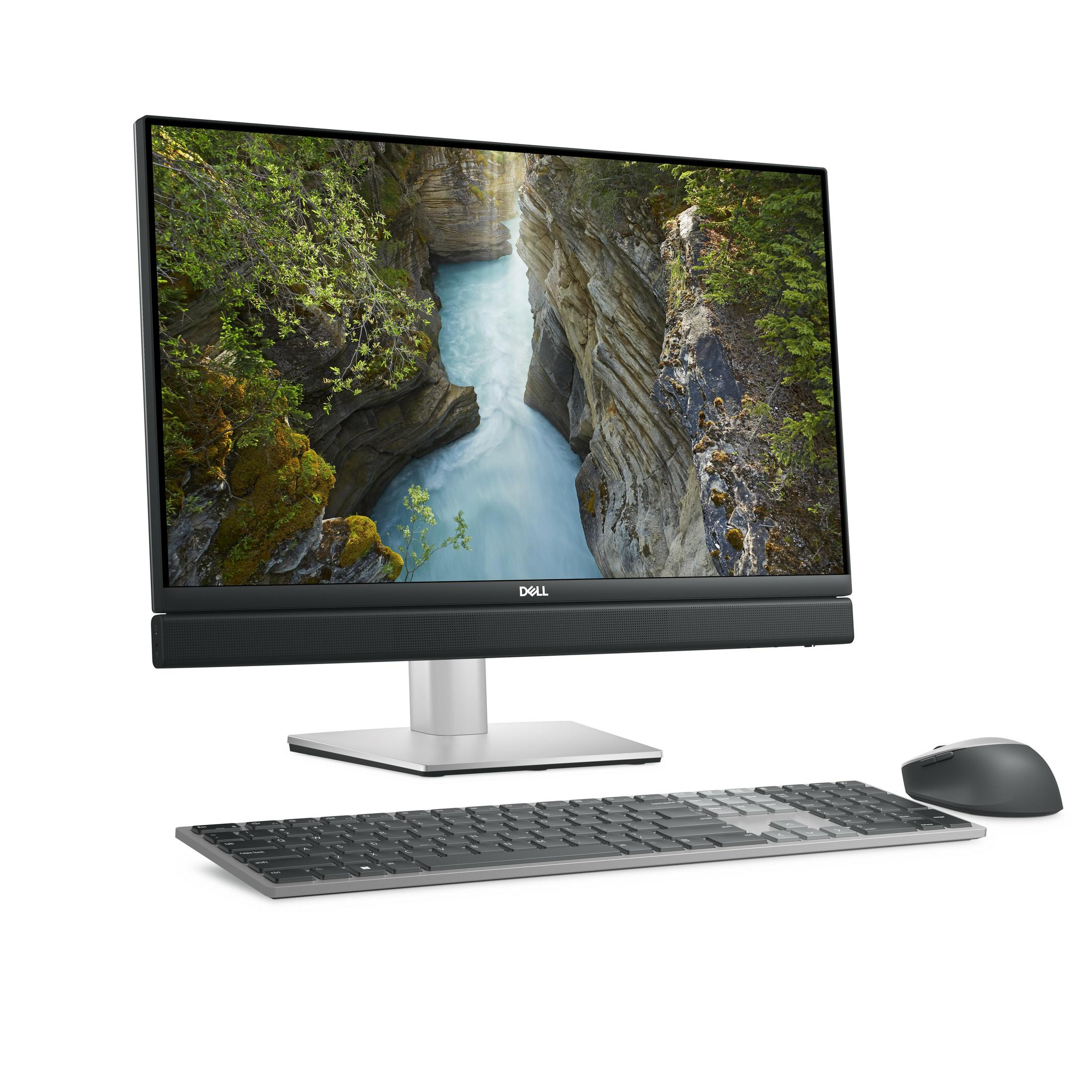 Un computer desktop all-in-one Dell con sfondo di canyon fluviale, tastiera grigia e mouse.