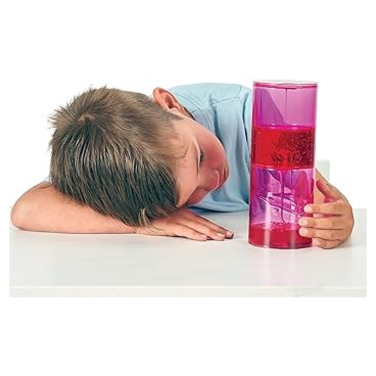 Ein Junge ruht seinen Kopf auf einem Tisch neben einem pinken Flüssigkeitsspielzeug.