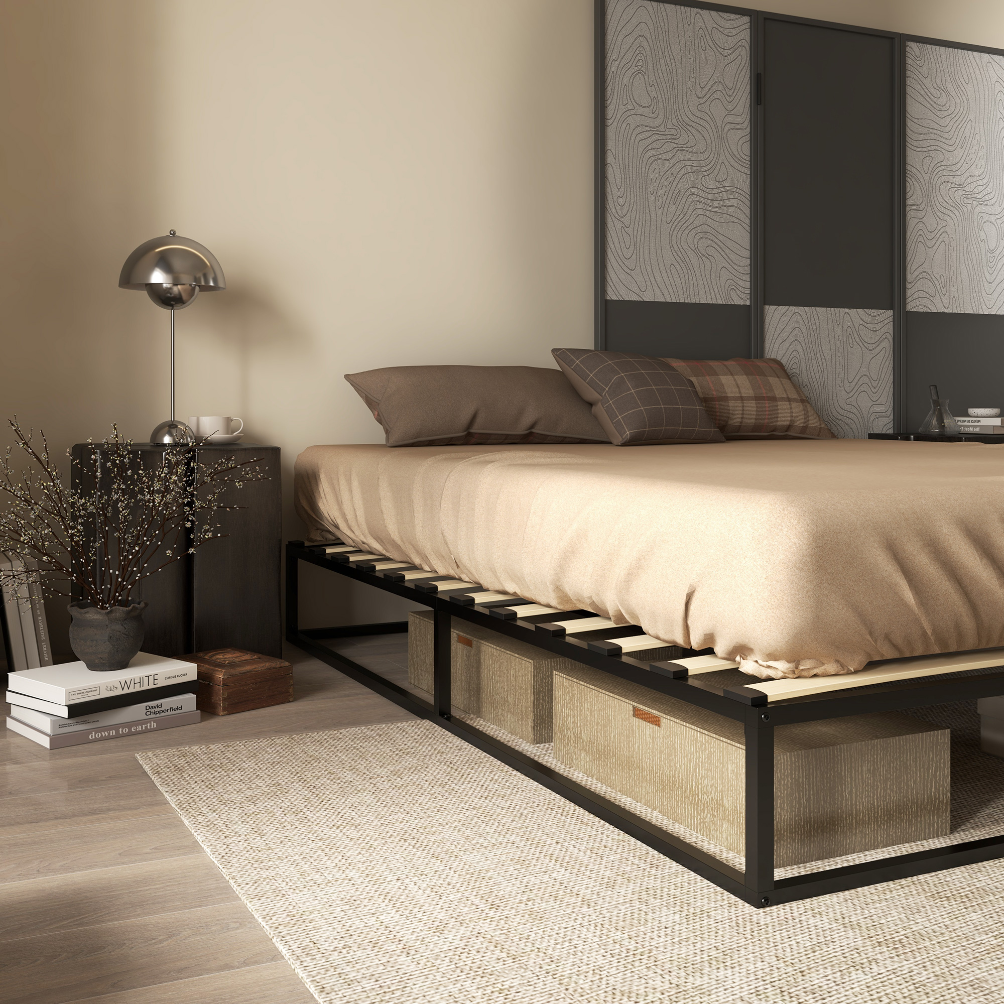 Cama moderna con cajas de almacenaje, mesita de noche con lámpara, libros y ramas en un dormitorio.