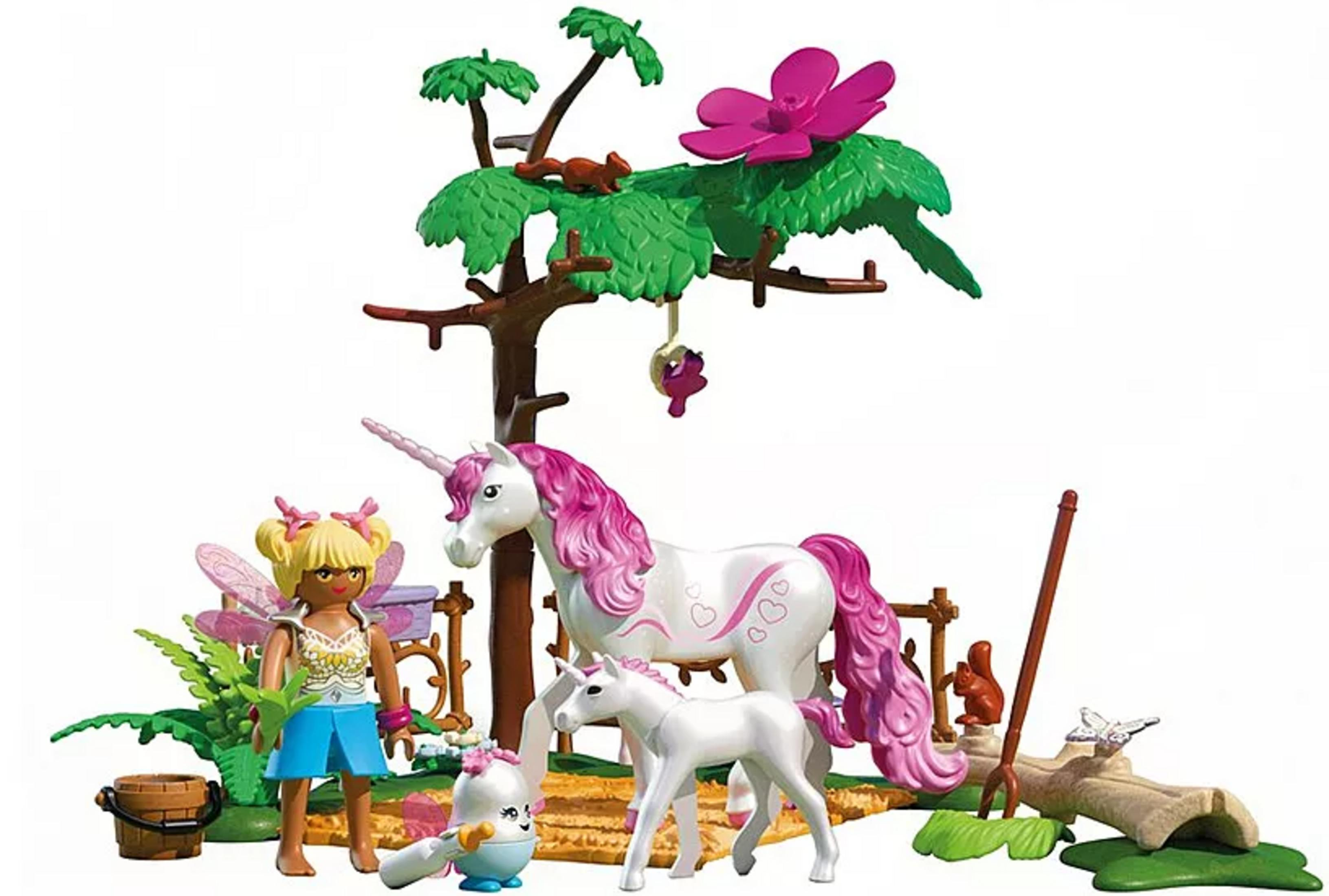 Eine Spielfigur, Einhörner und kleine Tiere unter einem Baum mit pinker Blume.