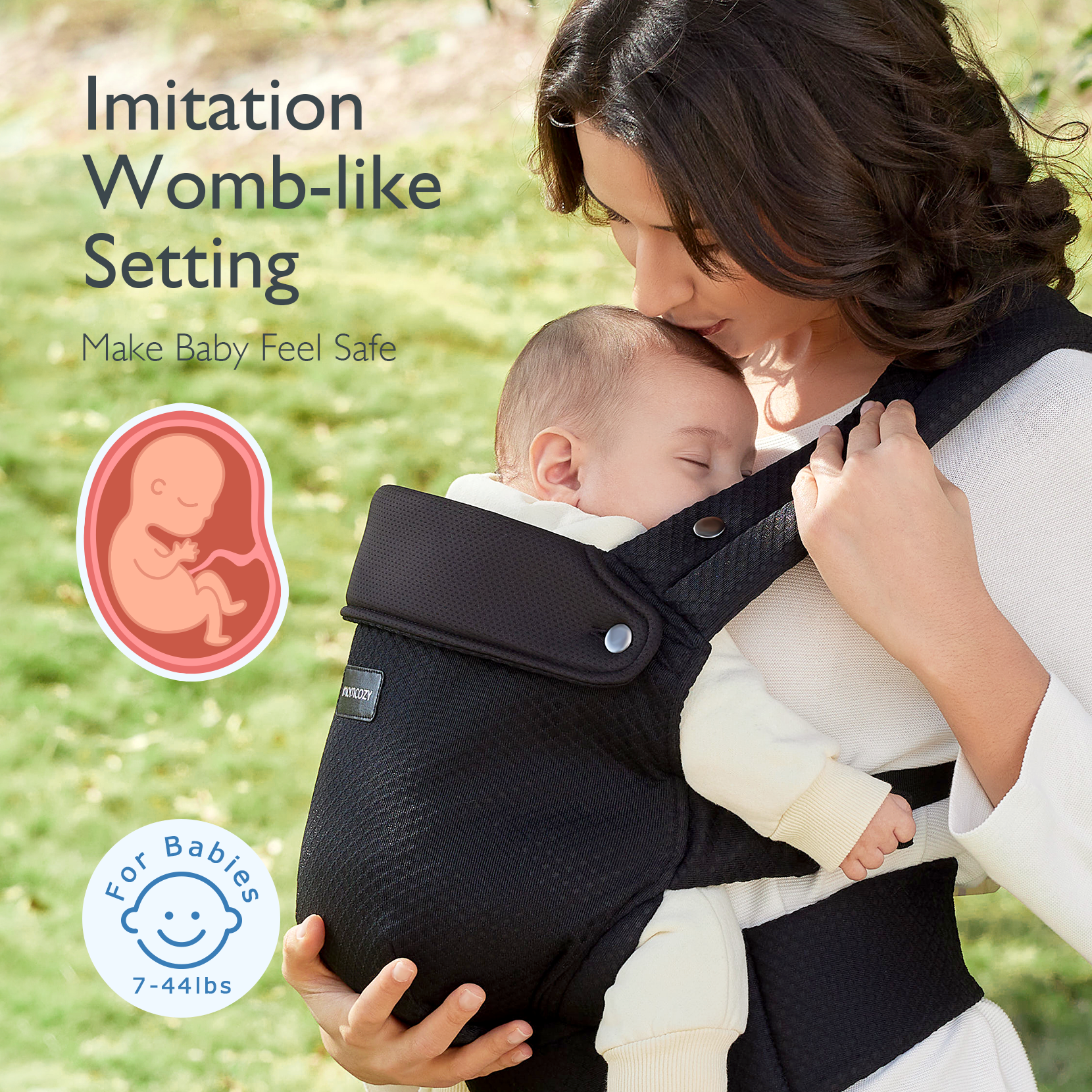 A mother gently kisses her sleeping baby, held securely on her chest in a black carrier.