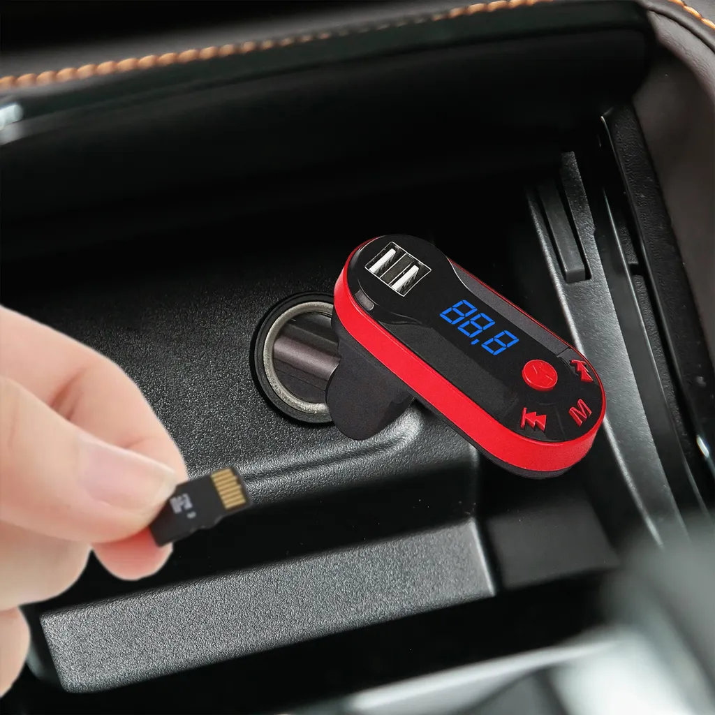 Ein roter und schwarzer Bluetooth-Autoadapter im Zigarettenanzünder, eine Hand hält eine Micro-SD-Karte.