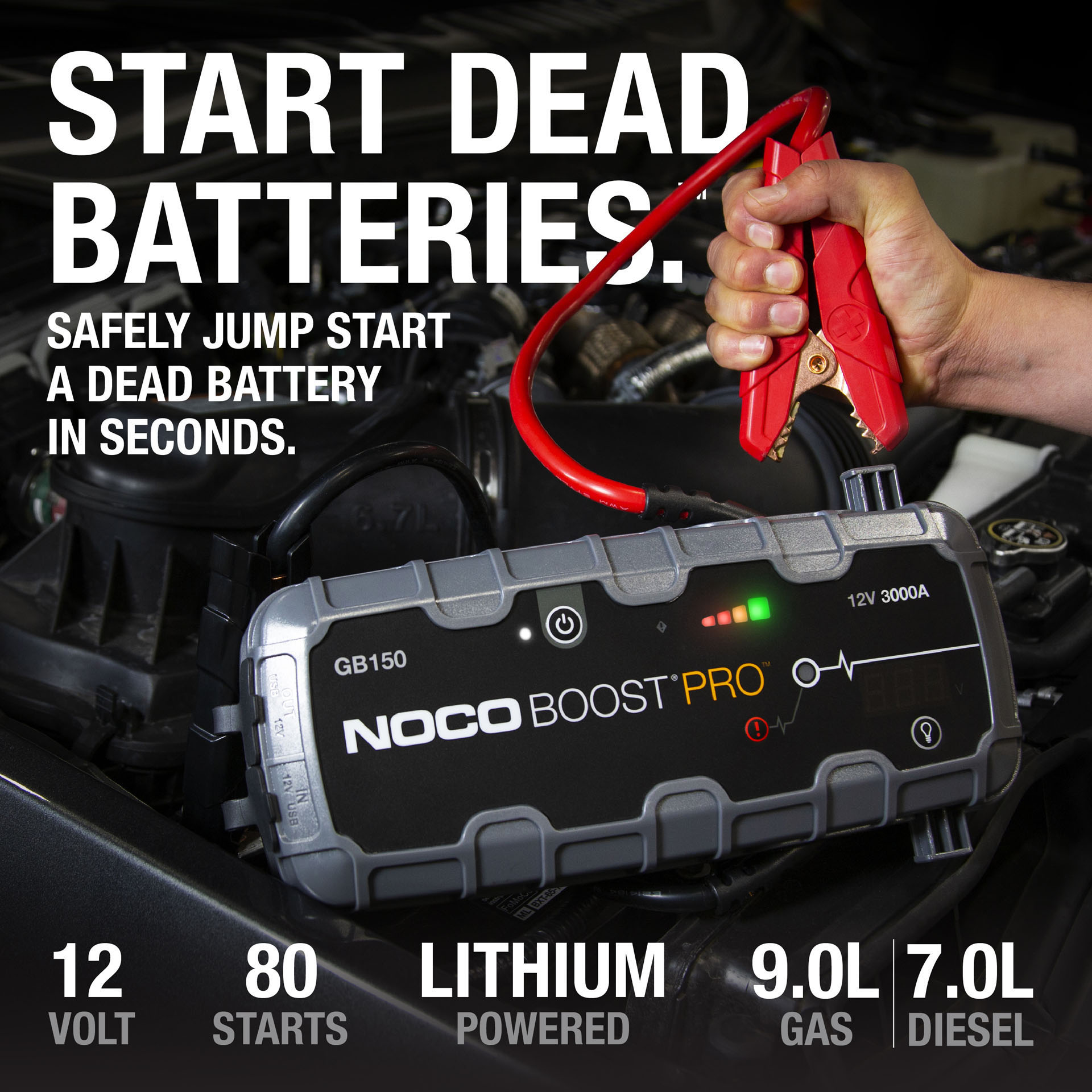 Ein NOCO Boost Pro Starthilfegerät liegt auf einem Automotor, eine Hand hält eine rote Klemme darüber.