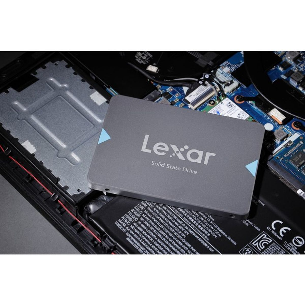 Eine Lexar Solid State Drive liegt auf den offenen Komponenten eines Laptops.