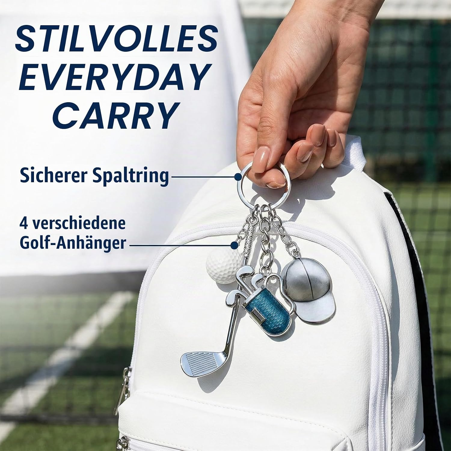 Hand hält Schlüsselring mit Golf-Anhängern vor weißem Rucksack.