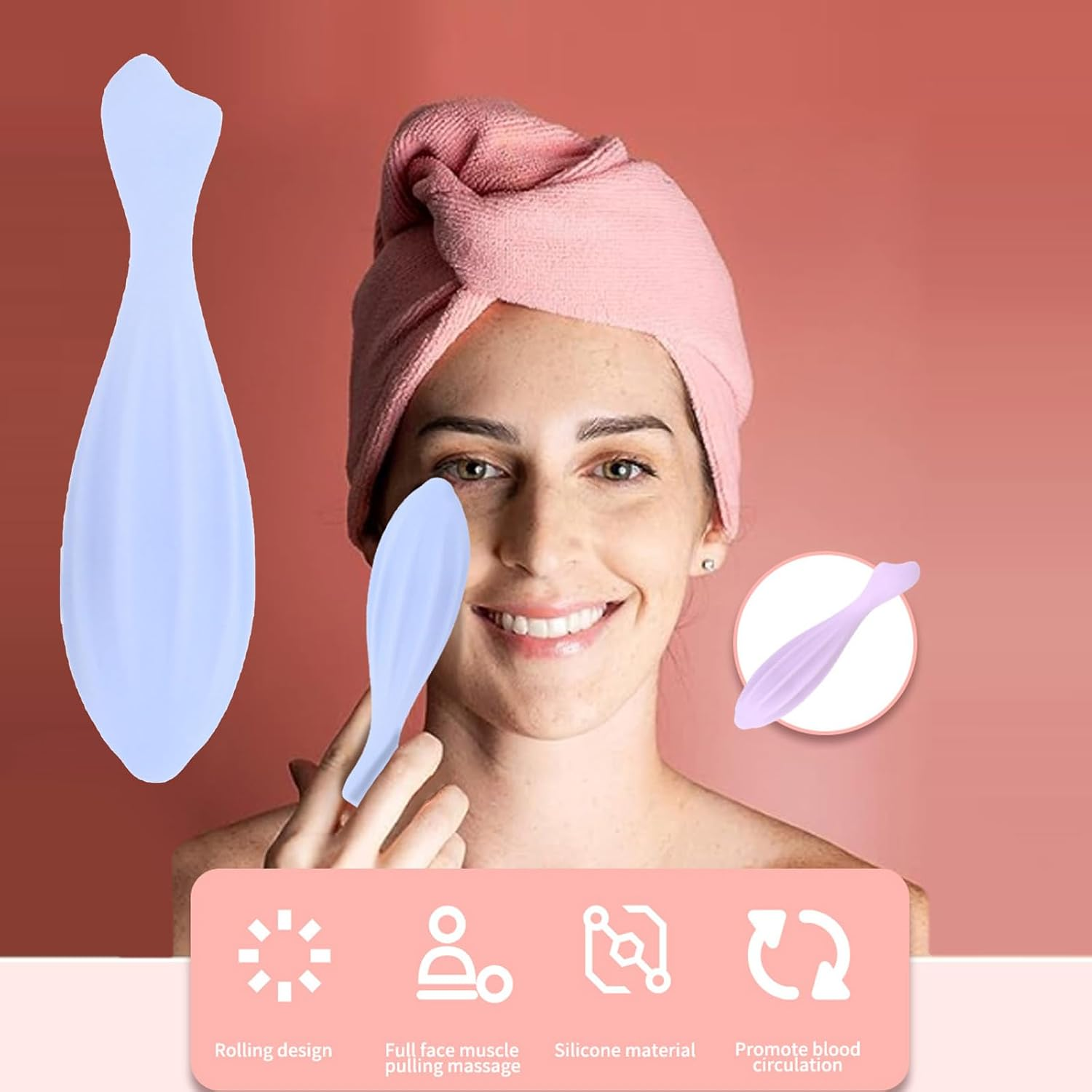 Eine lächelnde Frau mit rosa Handtuch auf dem Kopf hält ein blaues Gesichtsmassagetool vor rosa Hintergrund.