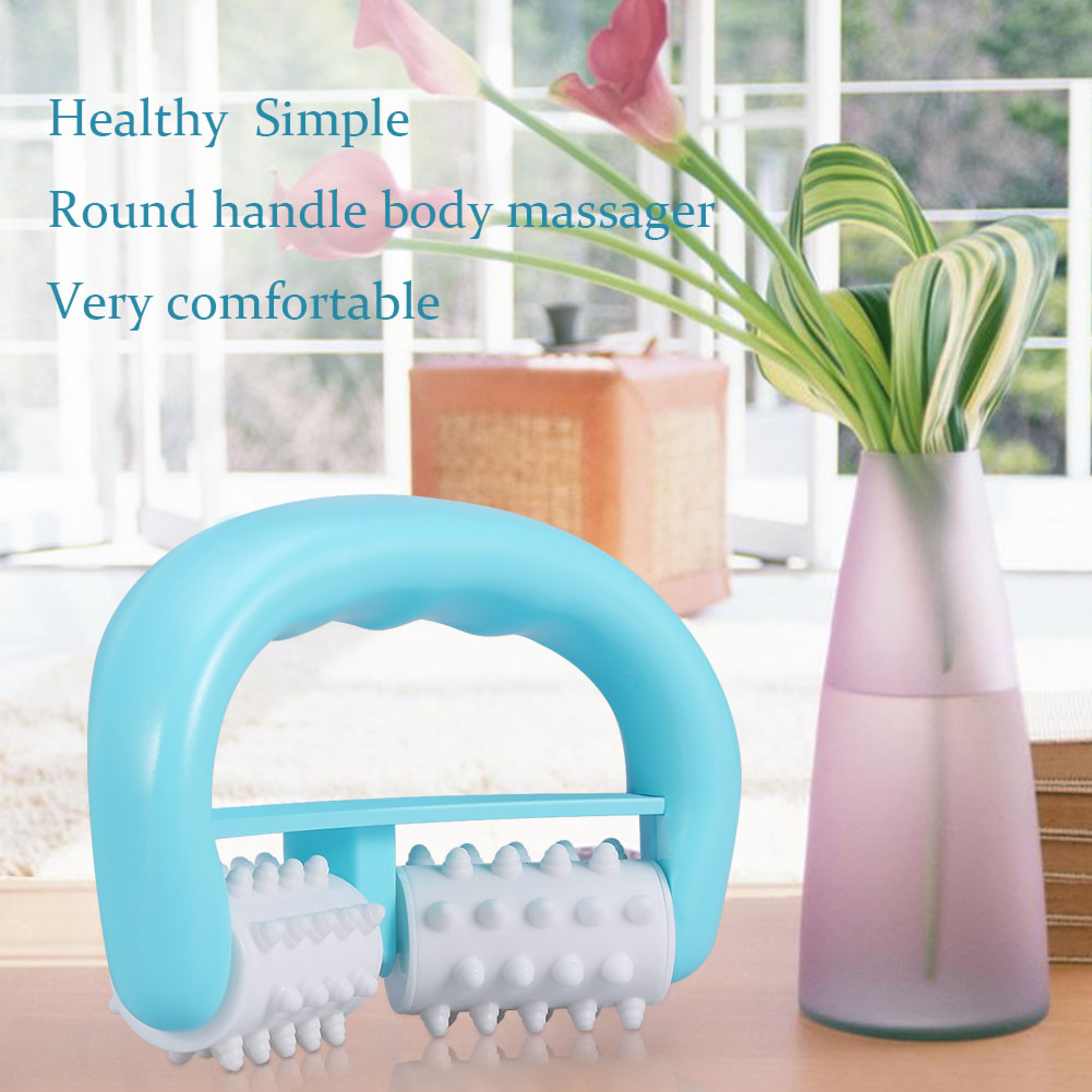 Ein blauer Körpermassager mit strukturierten weißen Rollen auf einem Holztisch neben einer Vase mit Blumen.